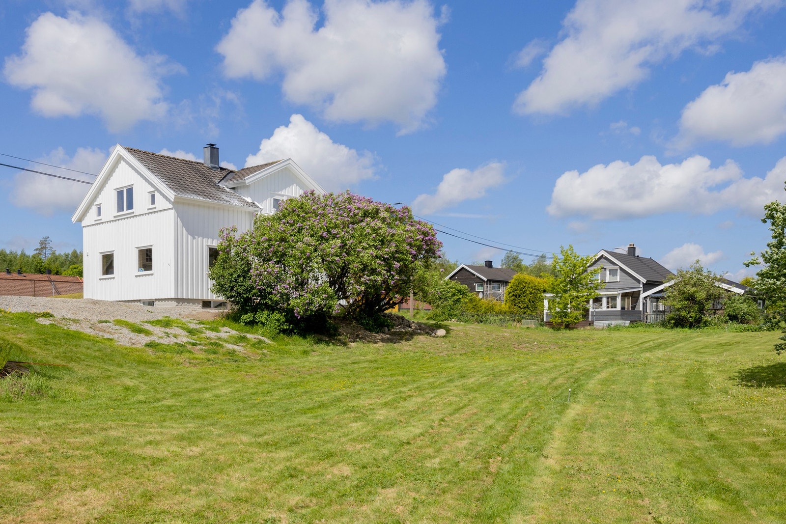 Relativt flat tomt men skrånende mot garasjen. Galleribilde