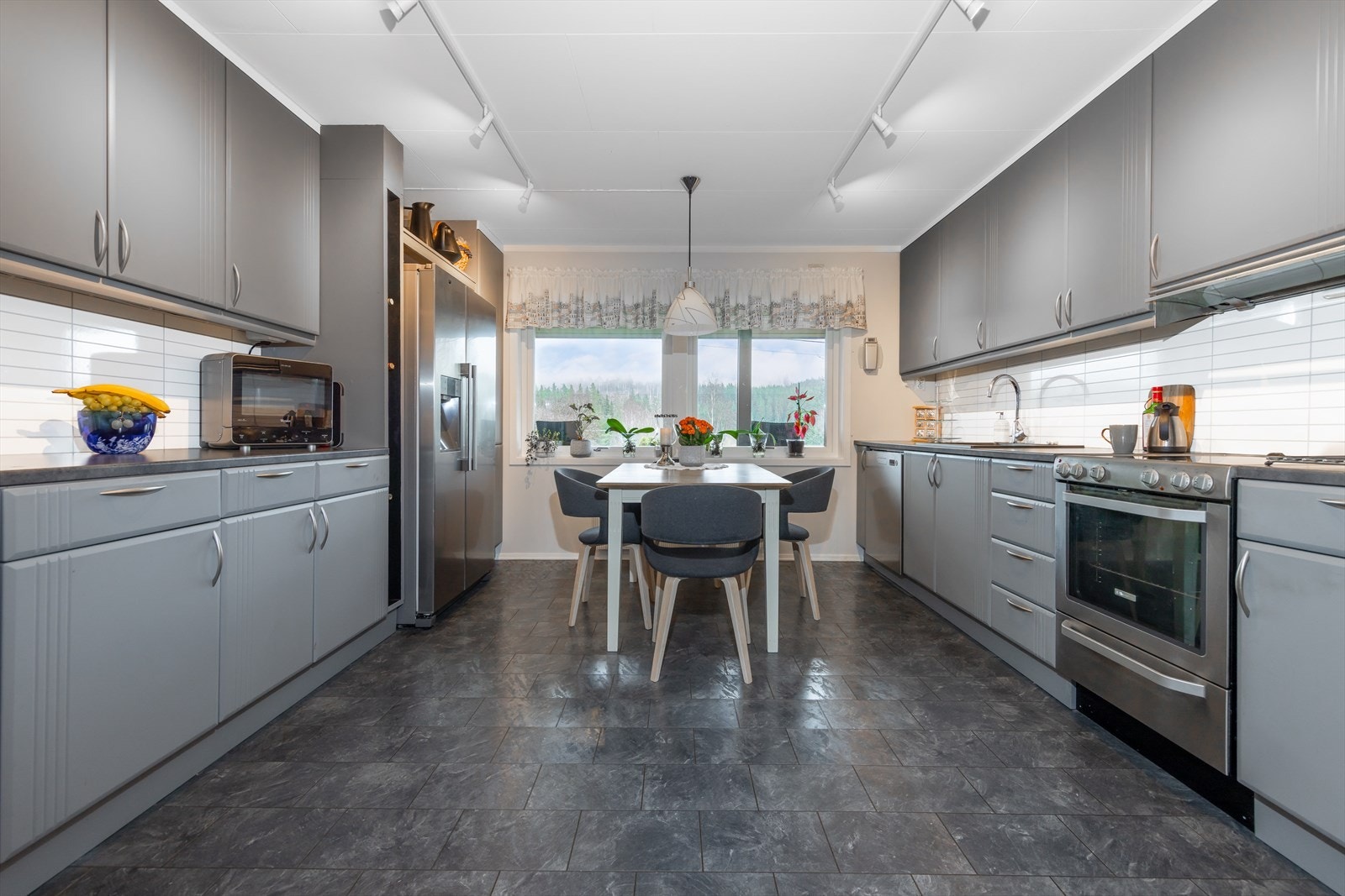 Kjøkken er av generøs størrelse med mye skap- og benkeplass Galleribilde