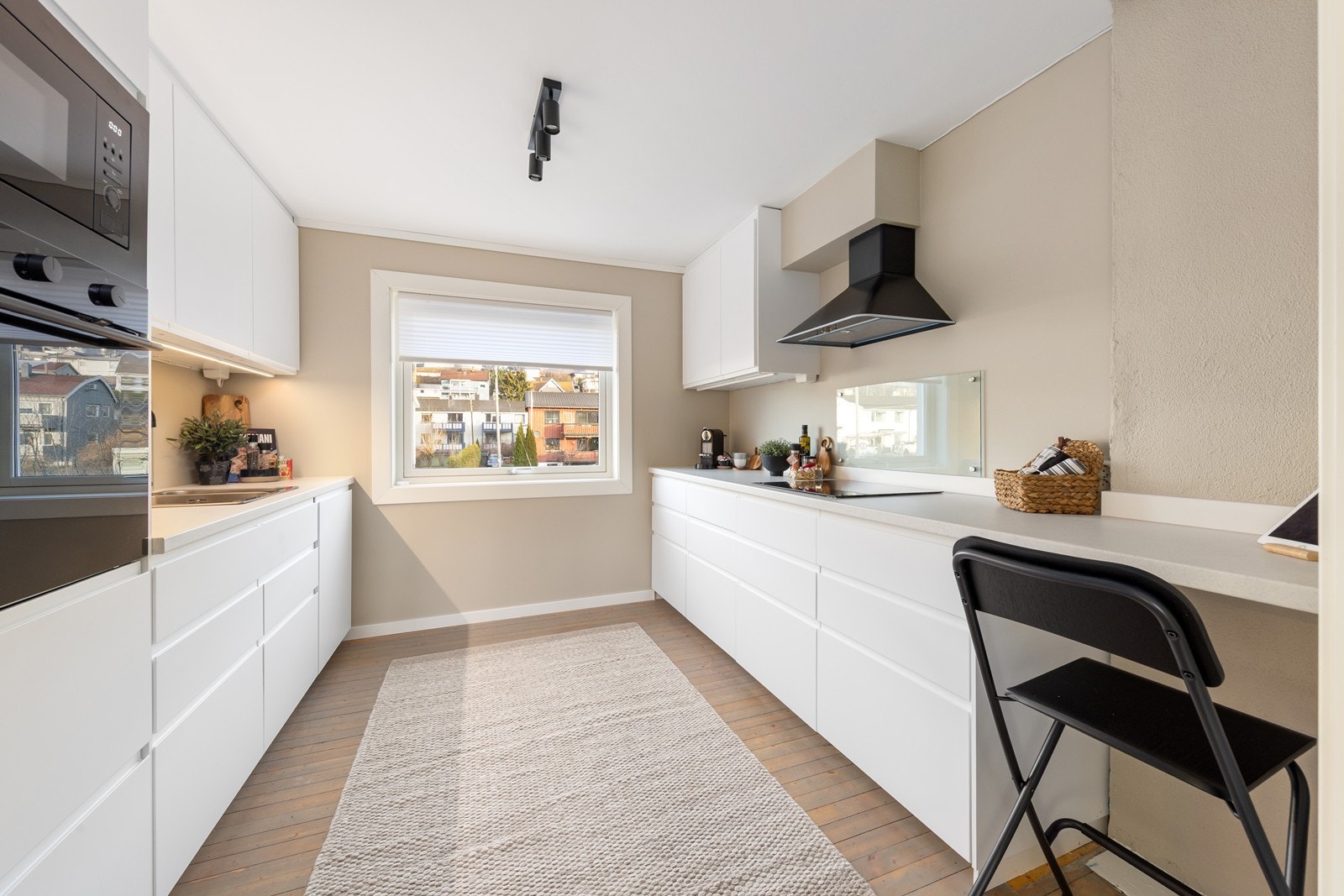 Integrerte hvitevarer bestående av kjøleskap, platetopp, micro og stekeovn. Det er kjøkkenventilator med avtrekk ut. Galleribilde