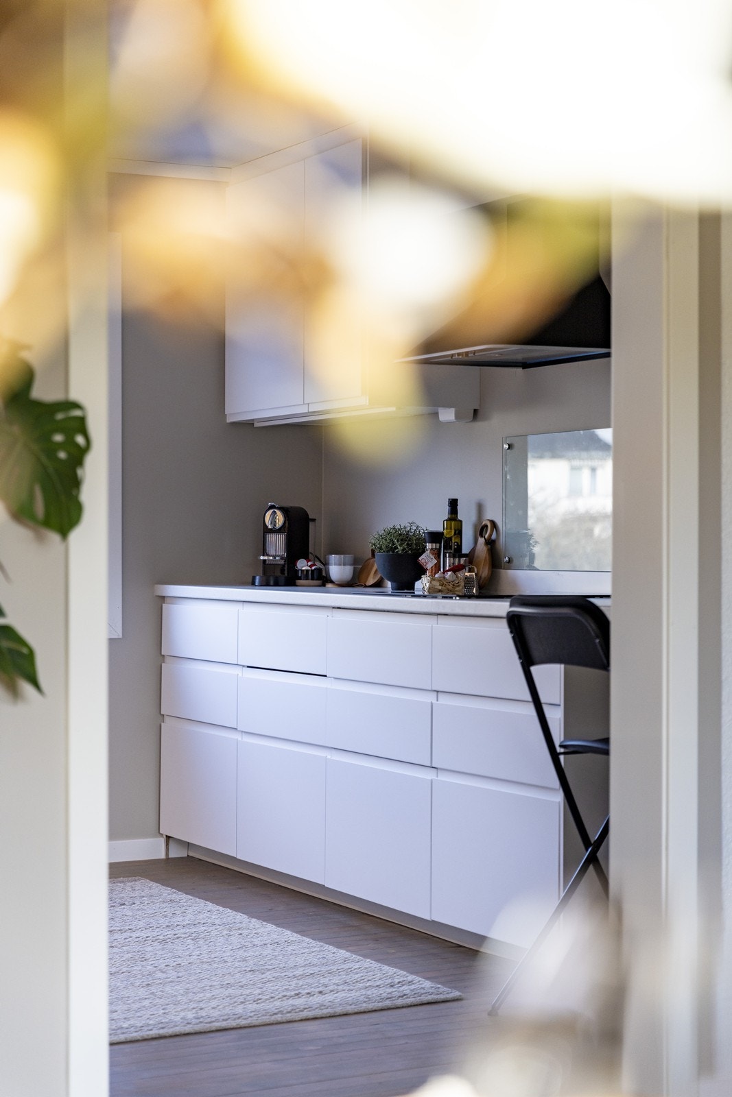 Kjøkkenet byr på en praktisk utforming og strekker seg fra vegg til vegg, noe som bidrar til mye benkeplass. Galleribilde