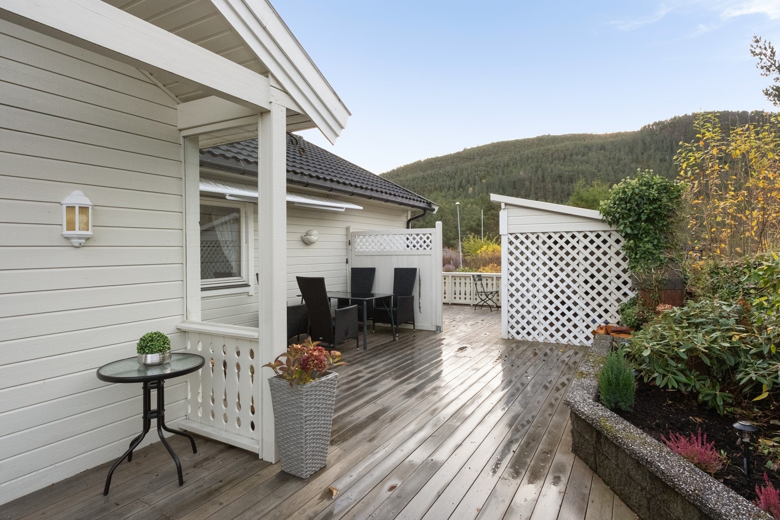 Verandaen strekker seg rundt flere sider, og det er satt opp levegger for å skjerme mot vind. Galleribilde