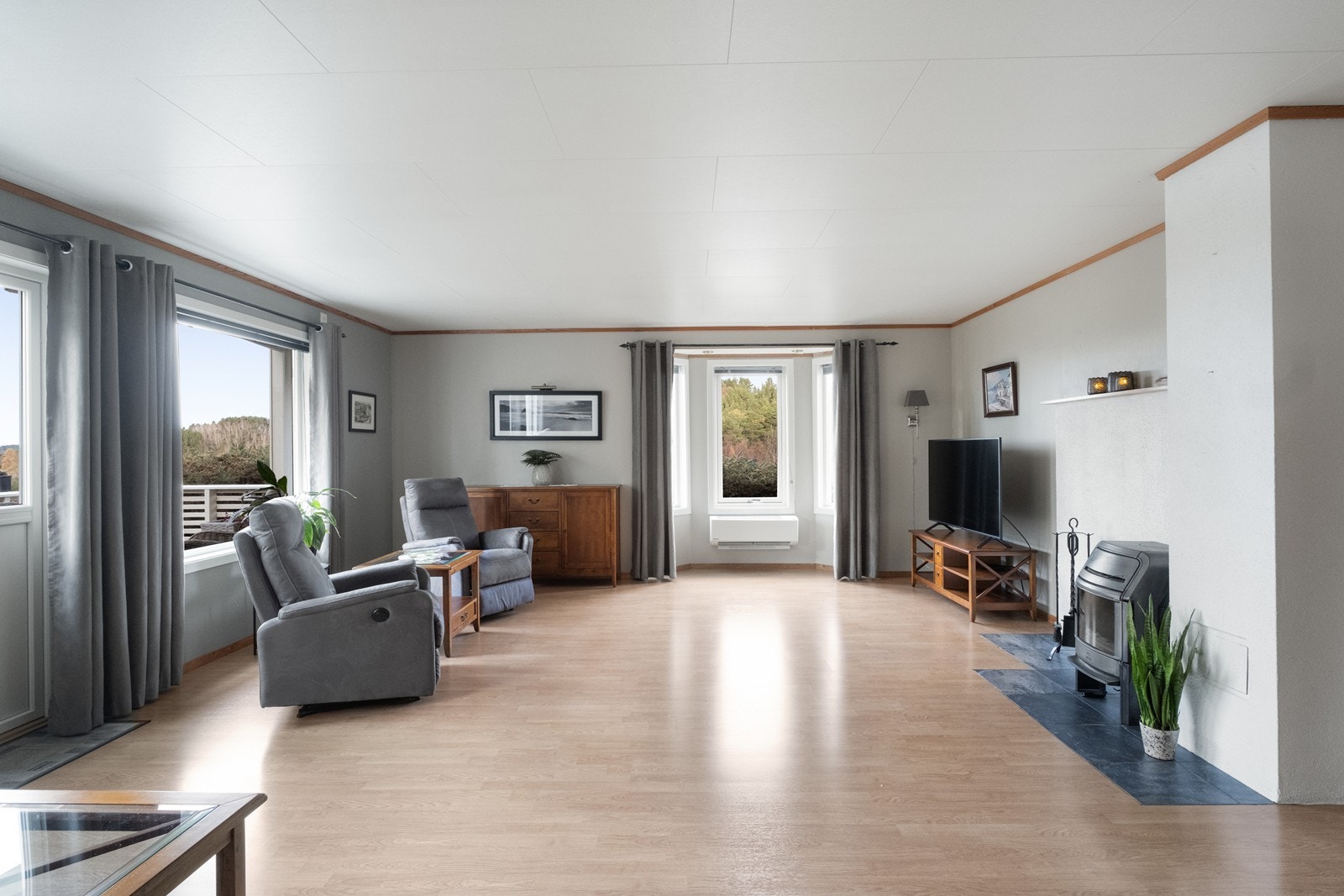 Stuen er stor og romslig, og det er montert både varmepumpe og peisovn. Galleribilde