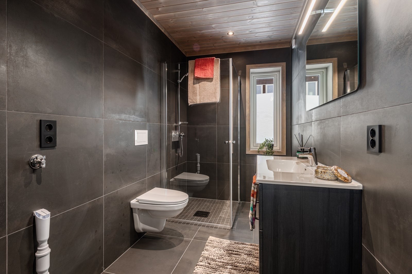 Baderom nr. 2 med heldekkende servant med skuffer, vegghengt toalett og dusjhjørne. Galleribilde