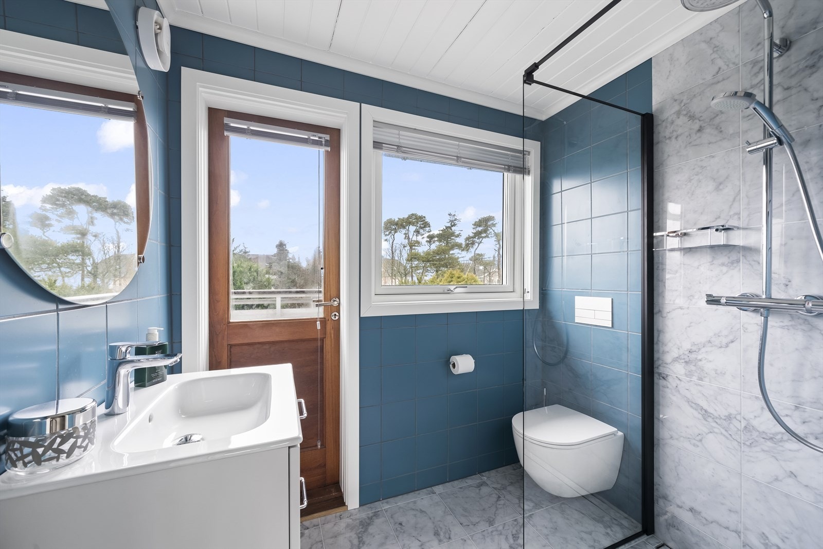 Bad i 2. etasje med utgang til en luftebalkong. Badet er smakfullt innredet med fliser på gulv og vegger, samt baderomsinnredning, toalett og dusjløsning. Varmekabler i gulv. Galleribilde