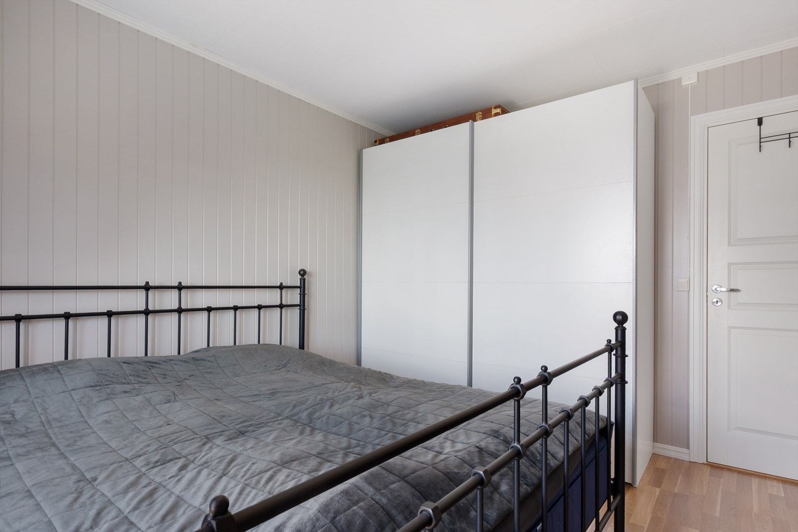 Rommet er innredet med garderobe med skyvedører, med lun farge på vegg og gyllent laminatgulv. Galleribilde