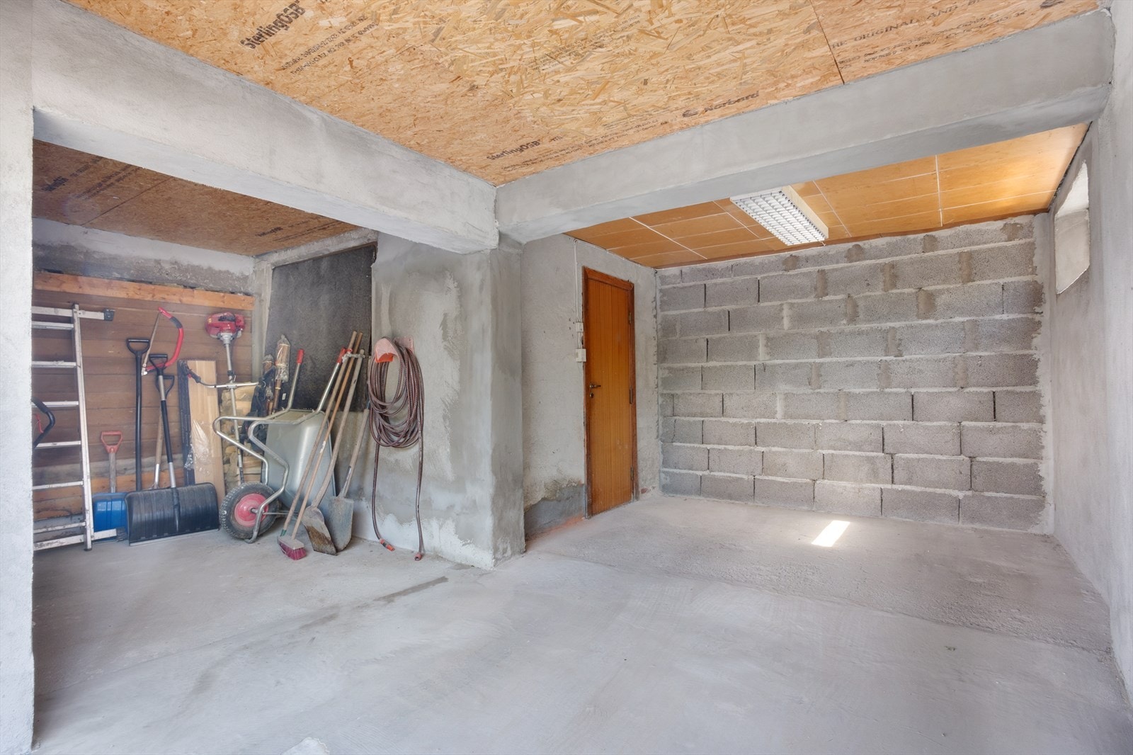 I kjeller har boligen parkering i åpen, integrert garasje med tilknyttet åpent lagringsareal for f.eks. hageredskaper o.l. Galleribilde