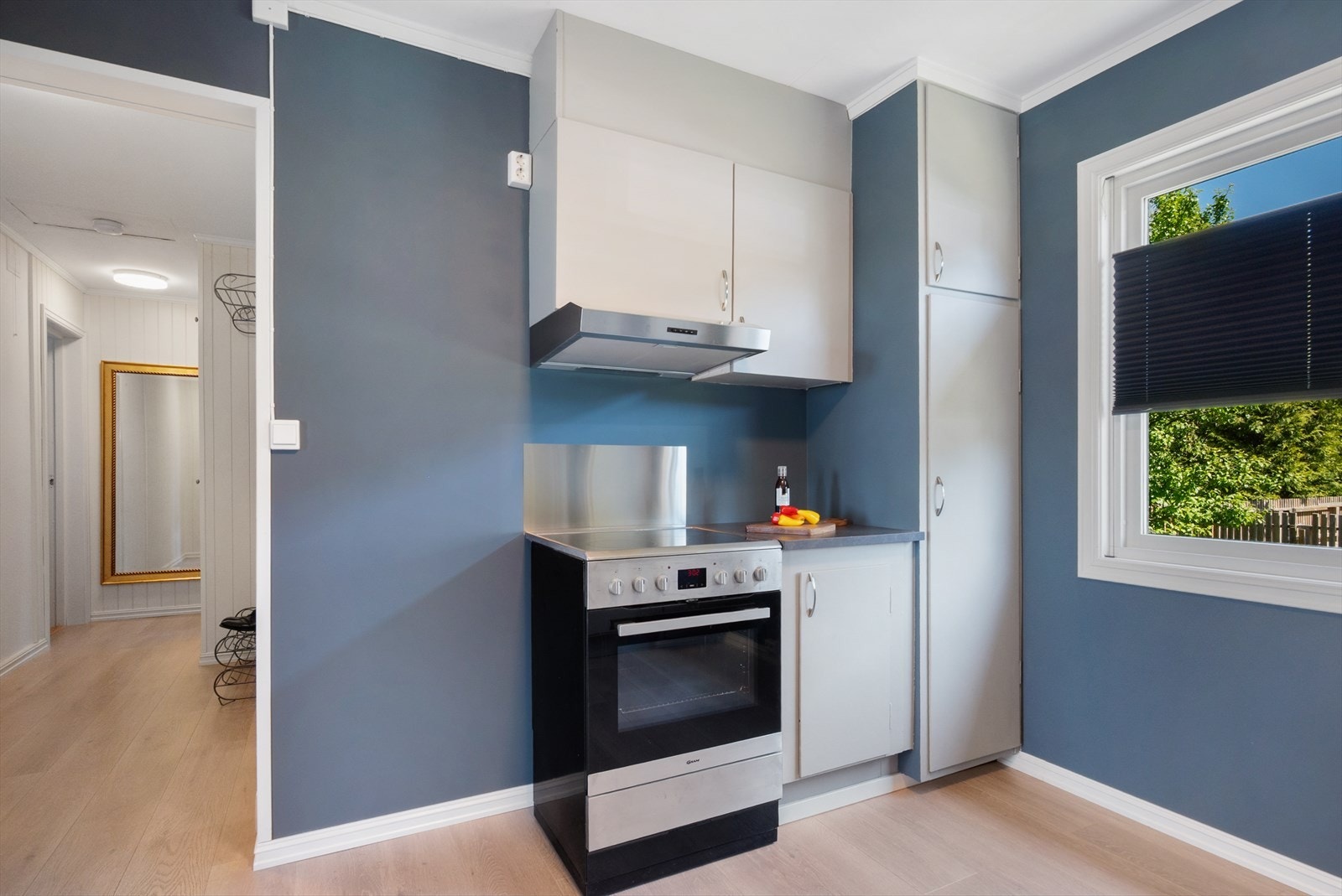 Innredningen har godt med oppbevaring. Frittstående komfyr medfølger og har montert beskyttelsesplate på vegg. Galleribilde