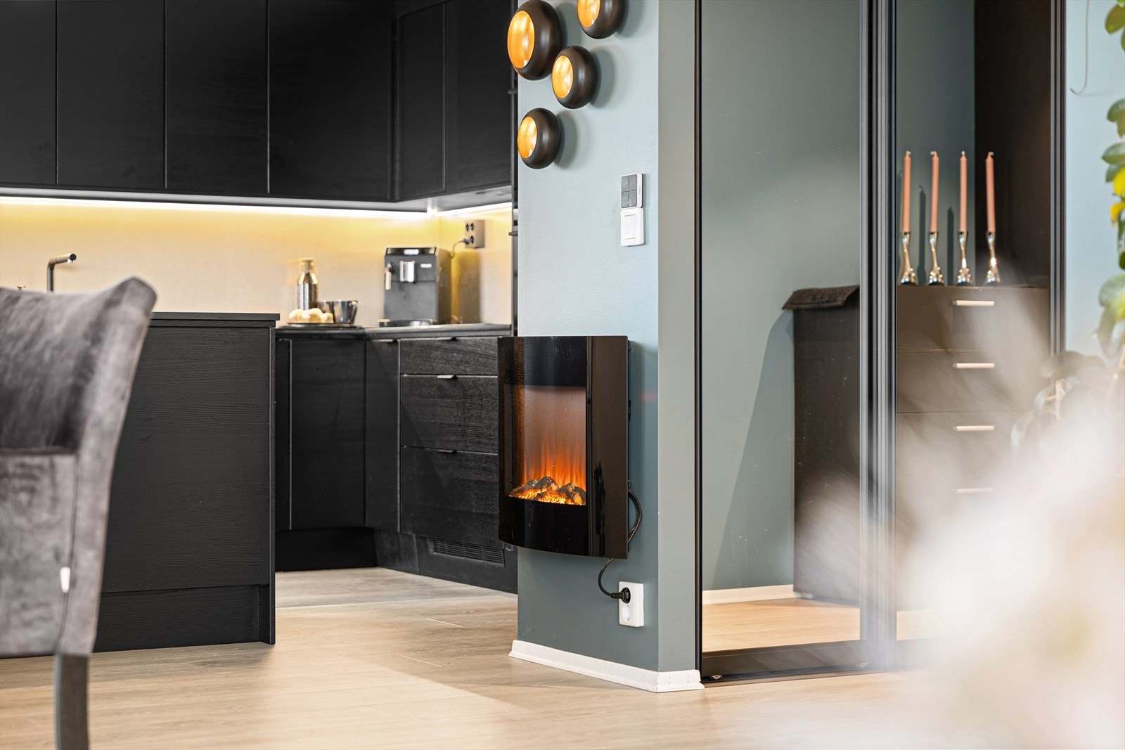 Ved spiseplassen står en moderne elektrisk peis som skaper varm atmosfære og ekstra hygge uten vedlikehold. Galleribilde