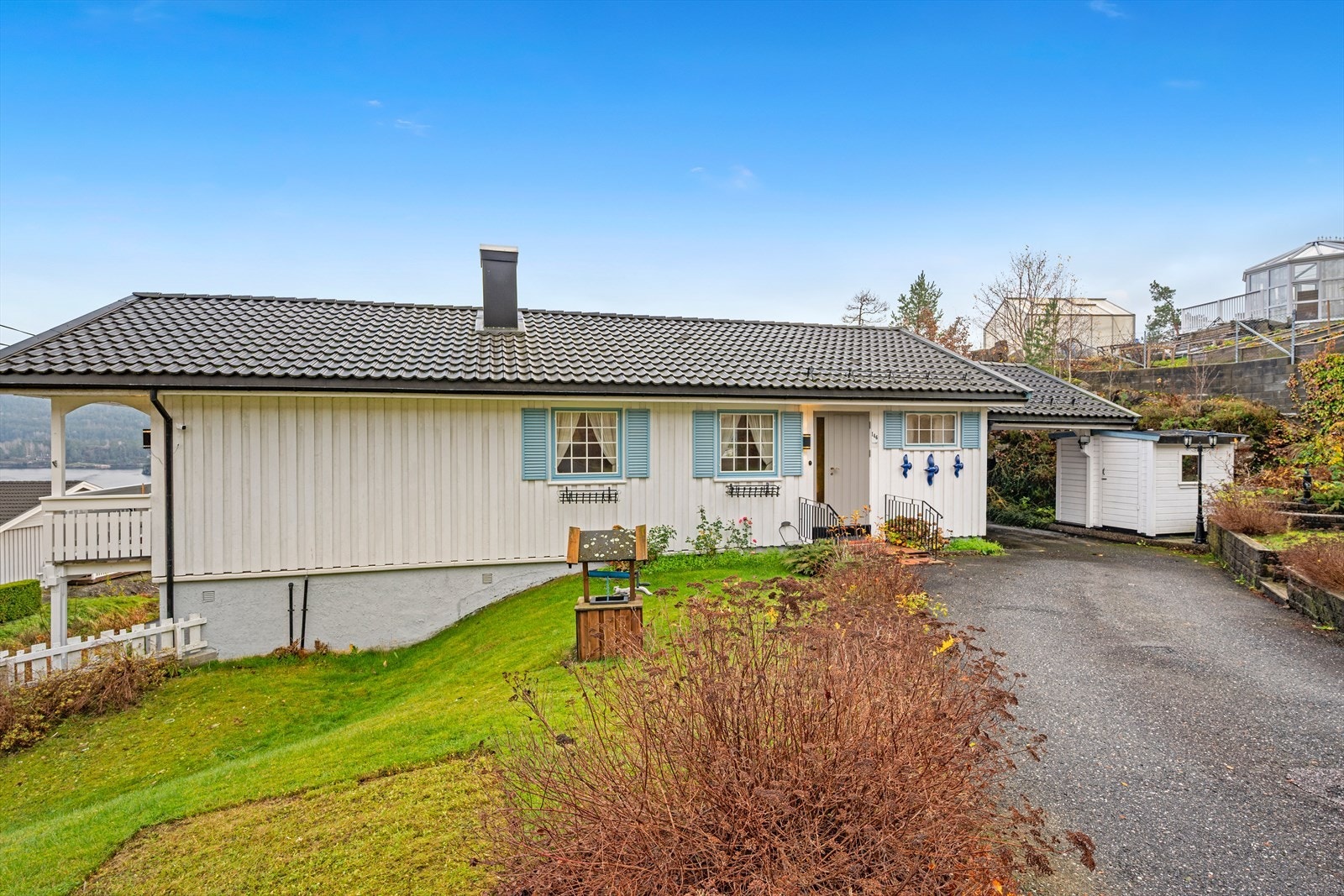 Det er asfaltert adkomst frem til boligen, med grøntarealer på begge siden av veien inn Galleribilde