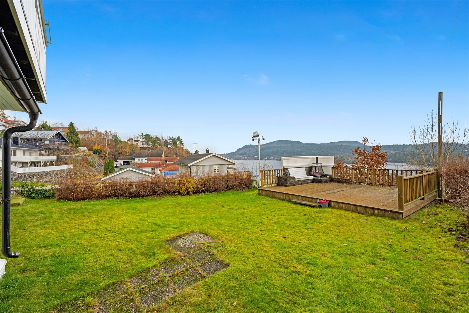 i Front er det en stor gressplen, samt en romslig platting med utepeis. Galleribilde