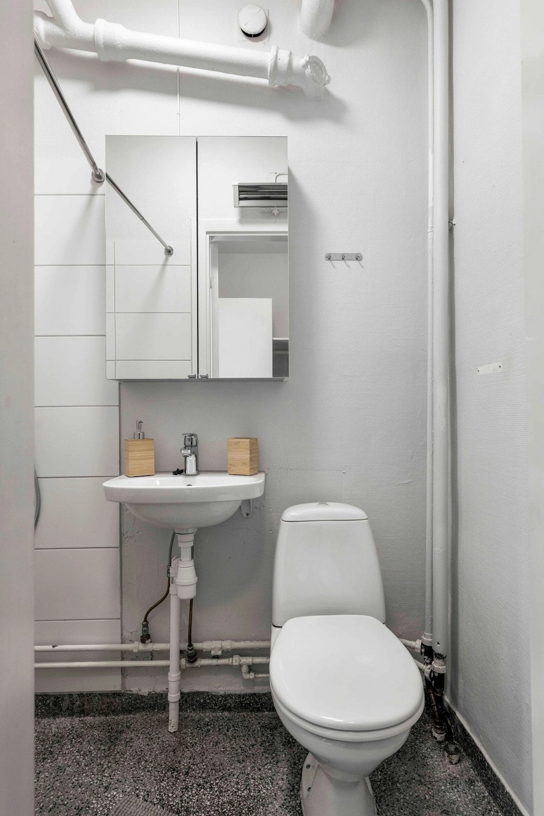 Bad utstyrt med toalett, servant og speilskap. Galleribilde