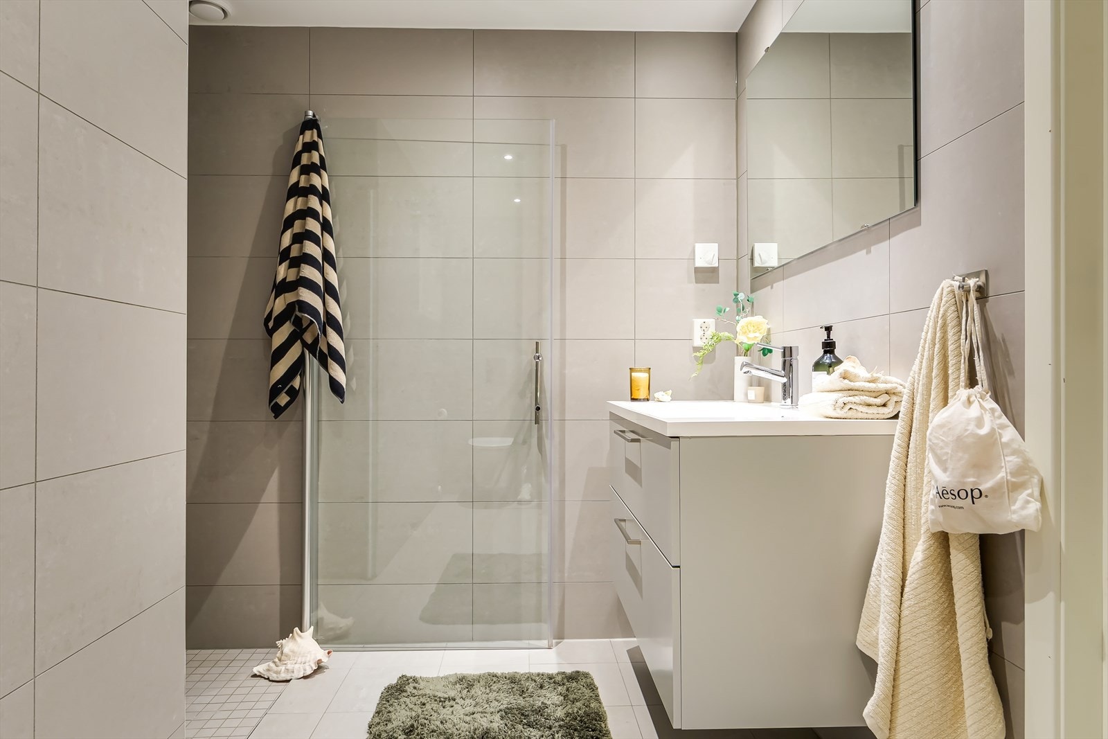 Fra entréen ligger det et bad | Badet er flislagt med store fliser på vegger og gulv, som gir et moderne uttrykk. Galleribilde