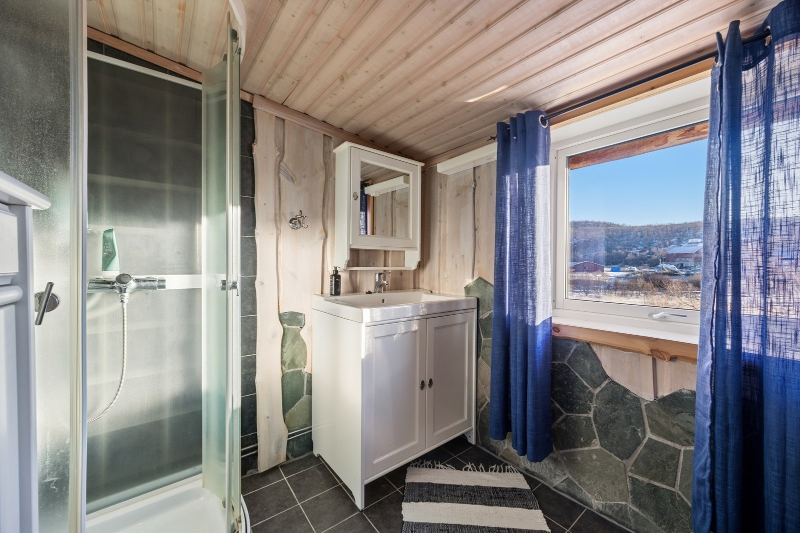 Badet ble oppgradert i ca. 2011. med flislagt gulv og vegger belagt med en kombinasjon av stein og panel Galleribilde