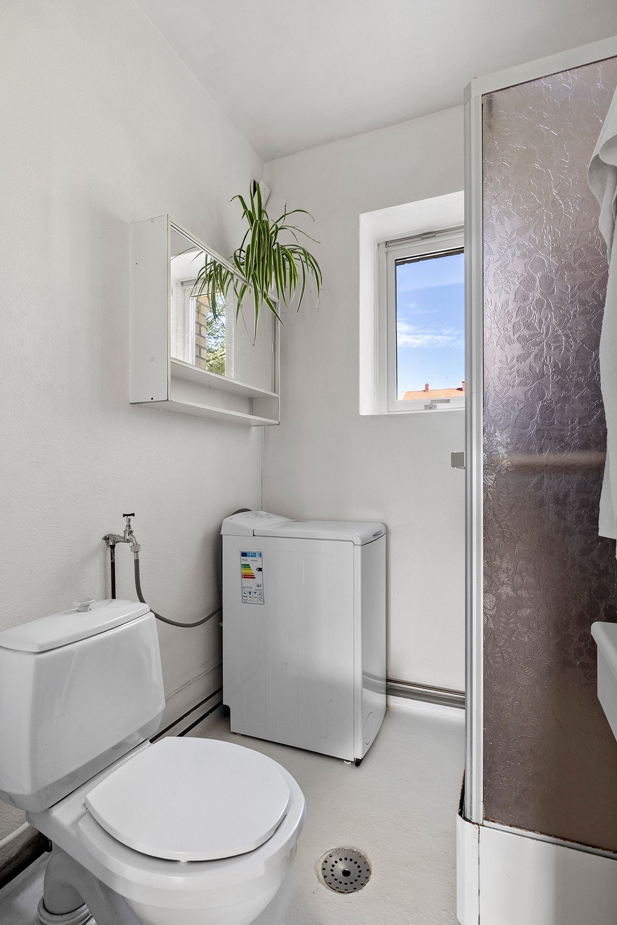 Eldre baderomsinnredning med dusjkabinett, servantskap og opplegg for vaskemaskin Galleribilde