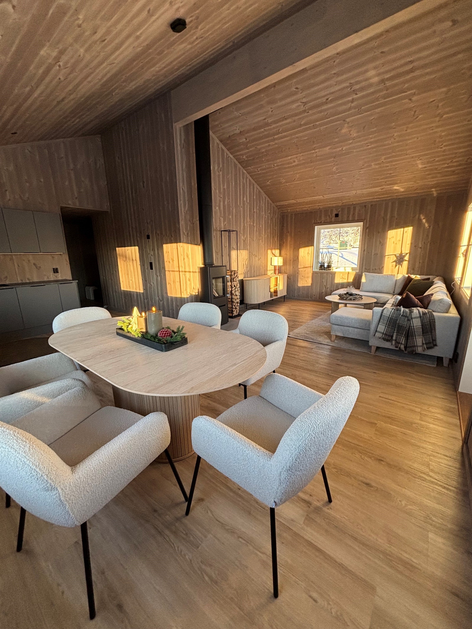 Luftig oppholdsrom med en deilig peisovn med glassdør Galleribilde