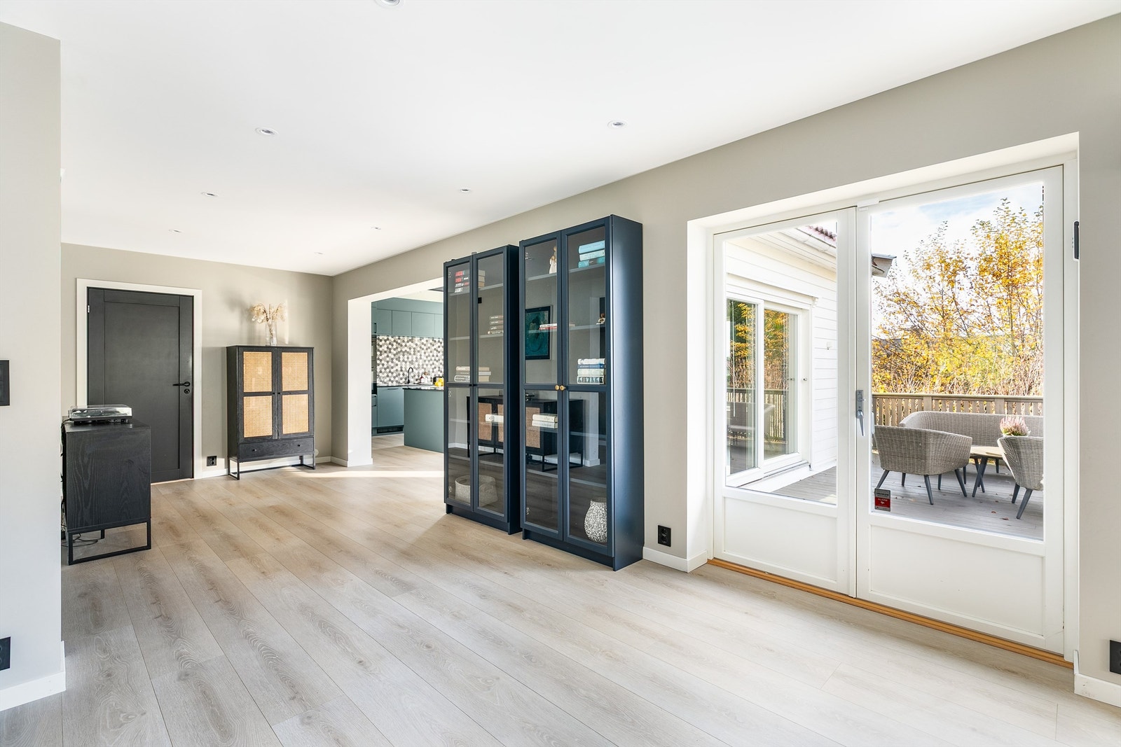 Én-stavs laminat er lagt gjennomgående og terskelfritt for et helhetlig uttrykk, blant annet mellom stuen og kjøkkenet. Galleribilde