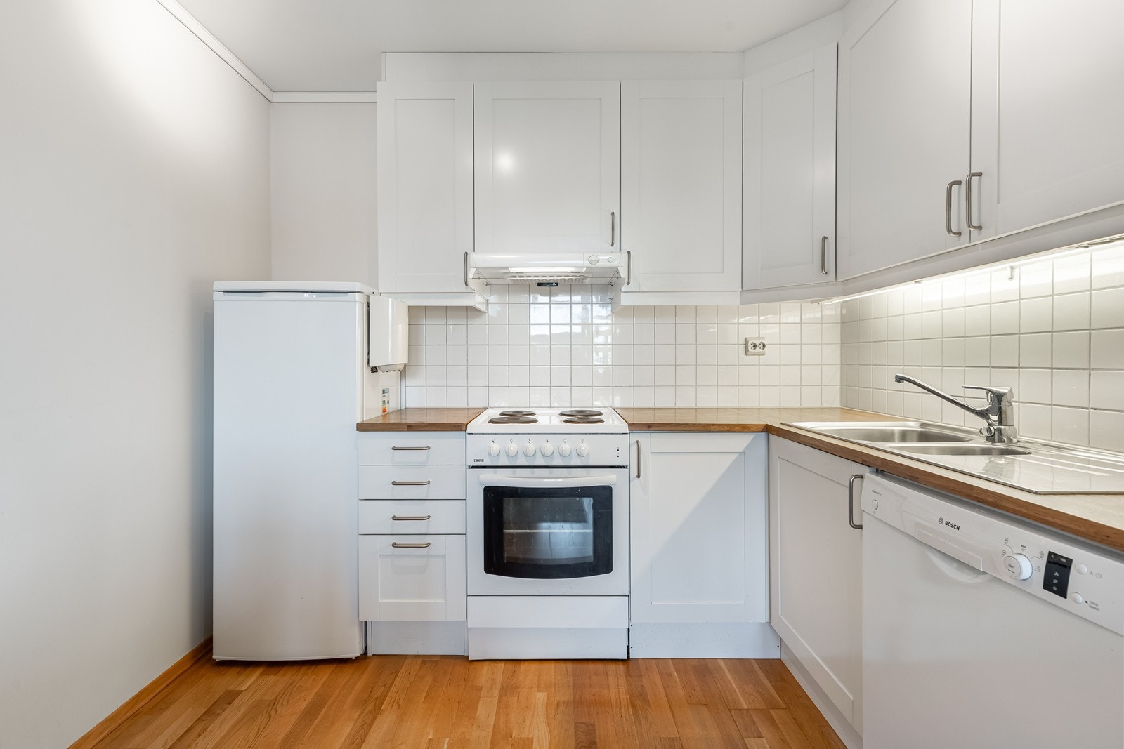 Praktisk kjøkken med hvitevarer - innredning helt til taket Galleribilde