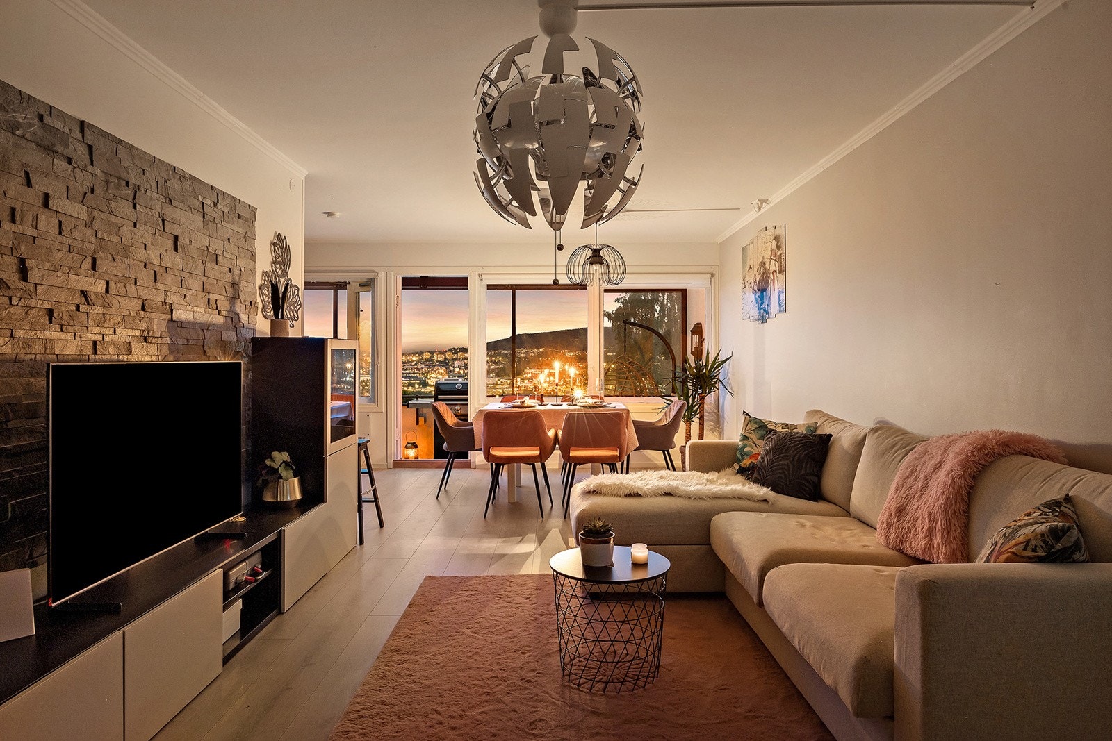 Boligen har en stor stue med steinbelagt kontrastvegg. Galleribilde