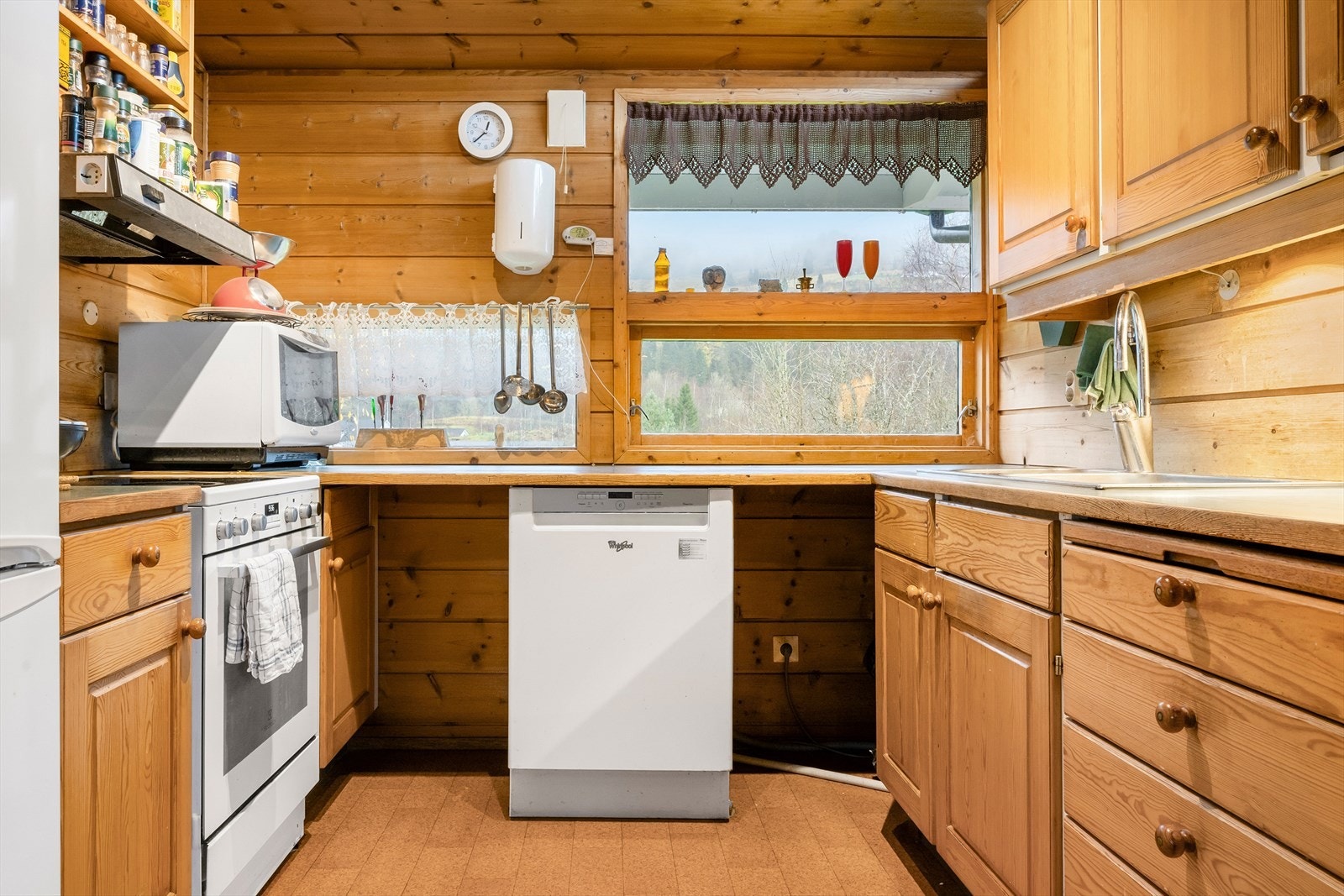 Kjøkken med innredning av heltre furu med frittstående hvitevarer. Galleribilde