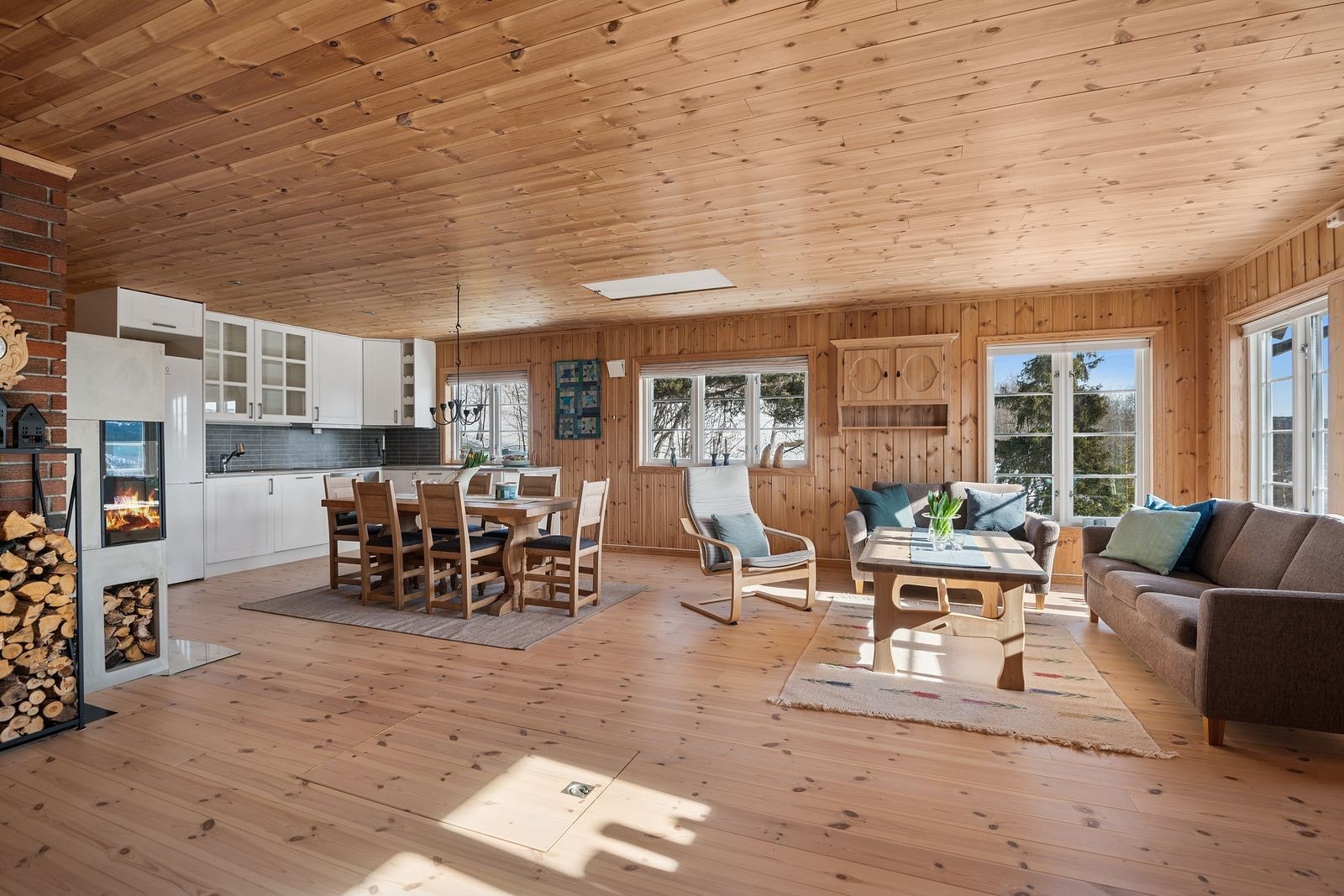 Vel inne ligger en tiltalende, lys og romslig stue med åpen kjøkkenløsning. Galleribilde