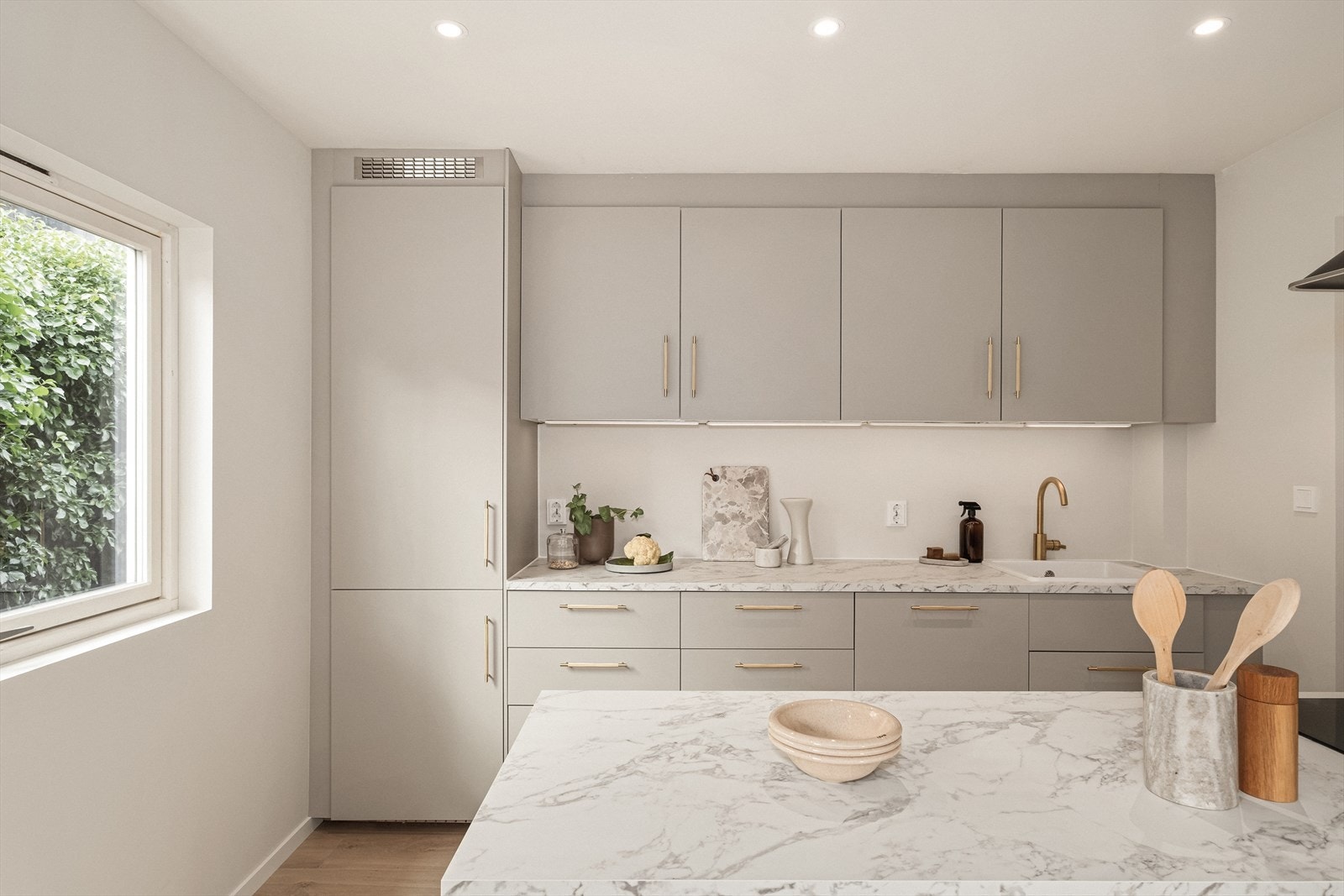 Pent og stilrent kjøkken fra 2025, med slette fronter og laminat benkeplate. Galleribilde