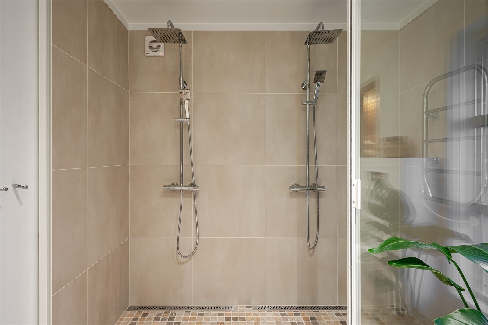 Dusjen er innredet med to vegghengte armaturer med både hånd- og regnfallsdusj, samt elektrisk håndkleholder. Galleribilde