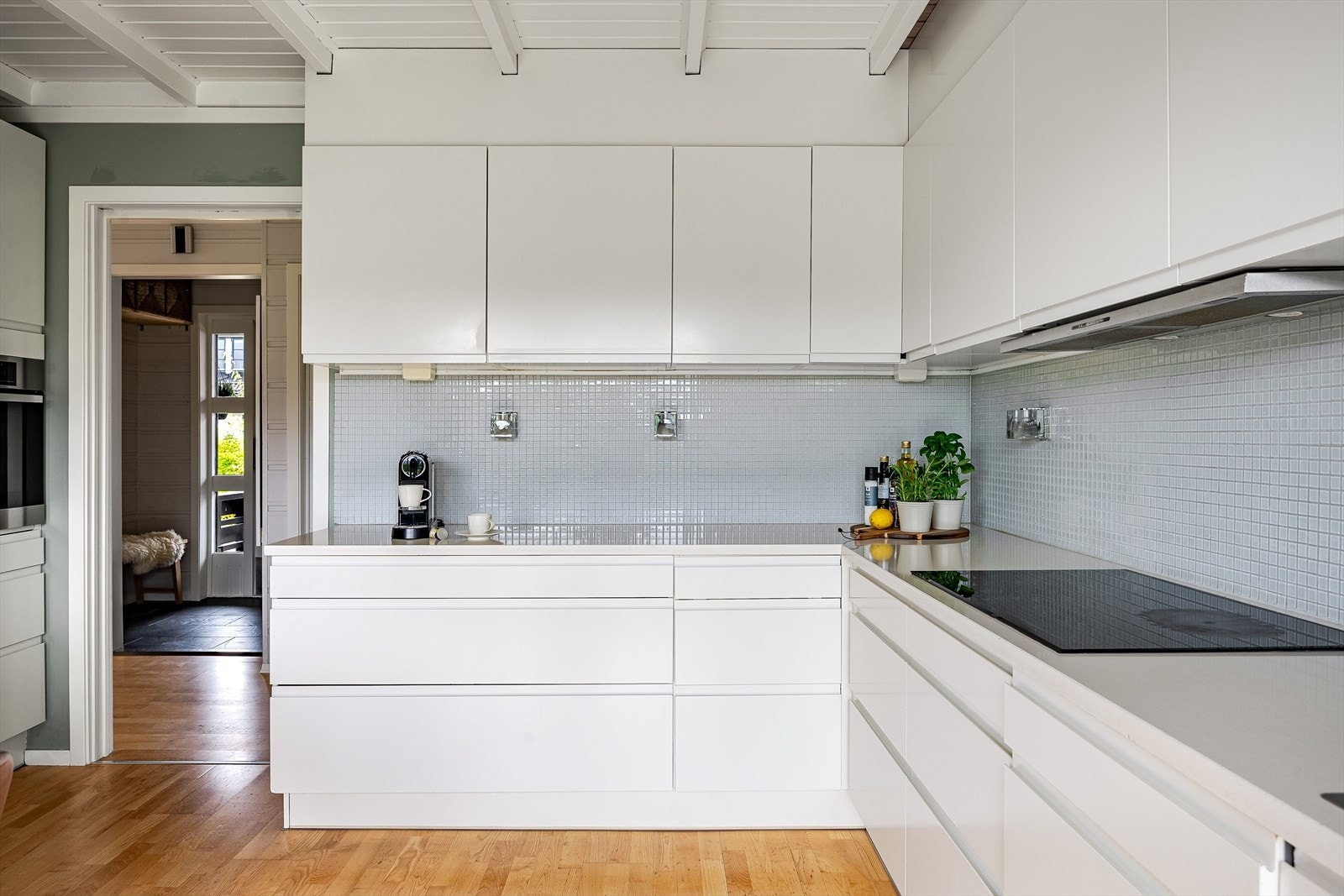 Både fint og praktisk med lyse mosaikkfliser i benkeryggen. Kjøkkenet er utstyrt med medfølgende integrerte hvitevarer som nedfelt induksjonstopp, avtrekksvifte, stekeovn i høyskap og oppvaskmaskin. Galleribilde