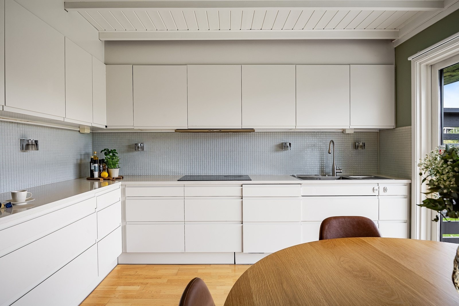 Lys og moderne kjøkkeninnredning fra 2011 med god skap- og benkeplass. Innredningen har hvite glatte fronter og laminert benkeplate med nedfelt oppvaskkum. Galleribilde