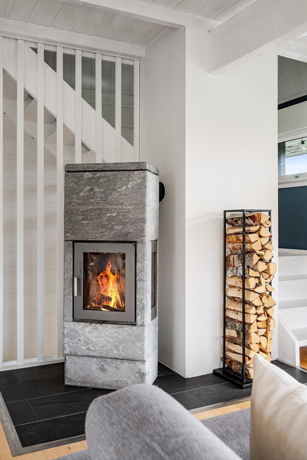 Som et fint midtpunkt i stuen er det en lekker klebersteinsovn som gir en god, langvarig varme, samt bidrar til ekstra hygge. Galleribilde