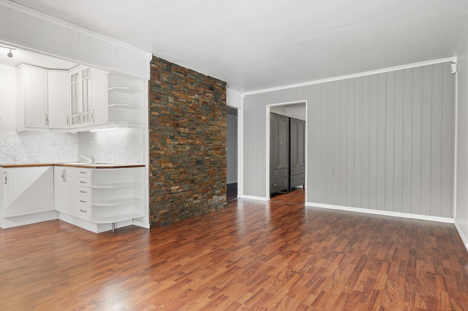 Her møtes du av en åpen løsning mellom stue og kjøkken, med en karakterfull fondvegg i steinpanel. Galleribilde