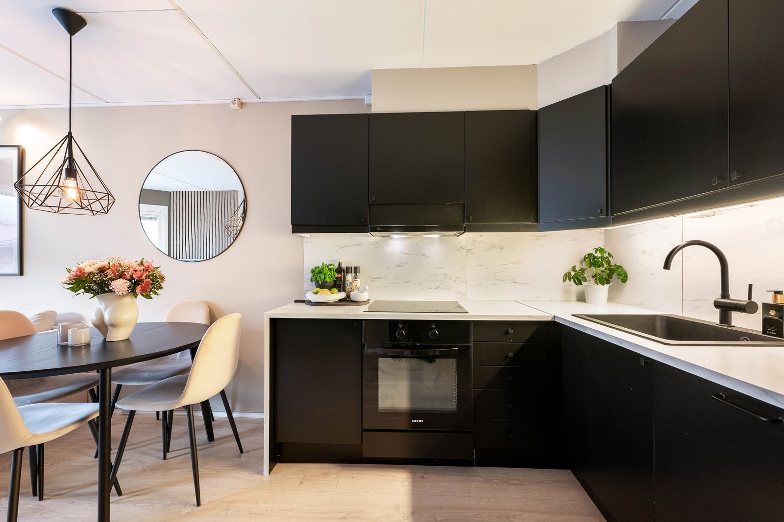 Stilrent kjøkken med integrerte hvitevarer (komfyr, platetopp, oppvaskmaskin) og moderne detaljer. Galleribilde