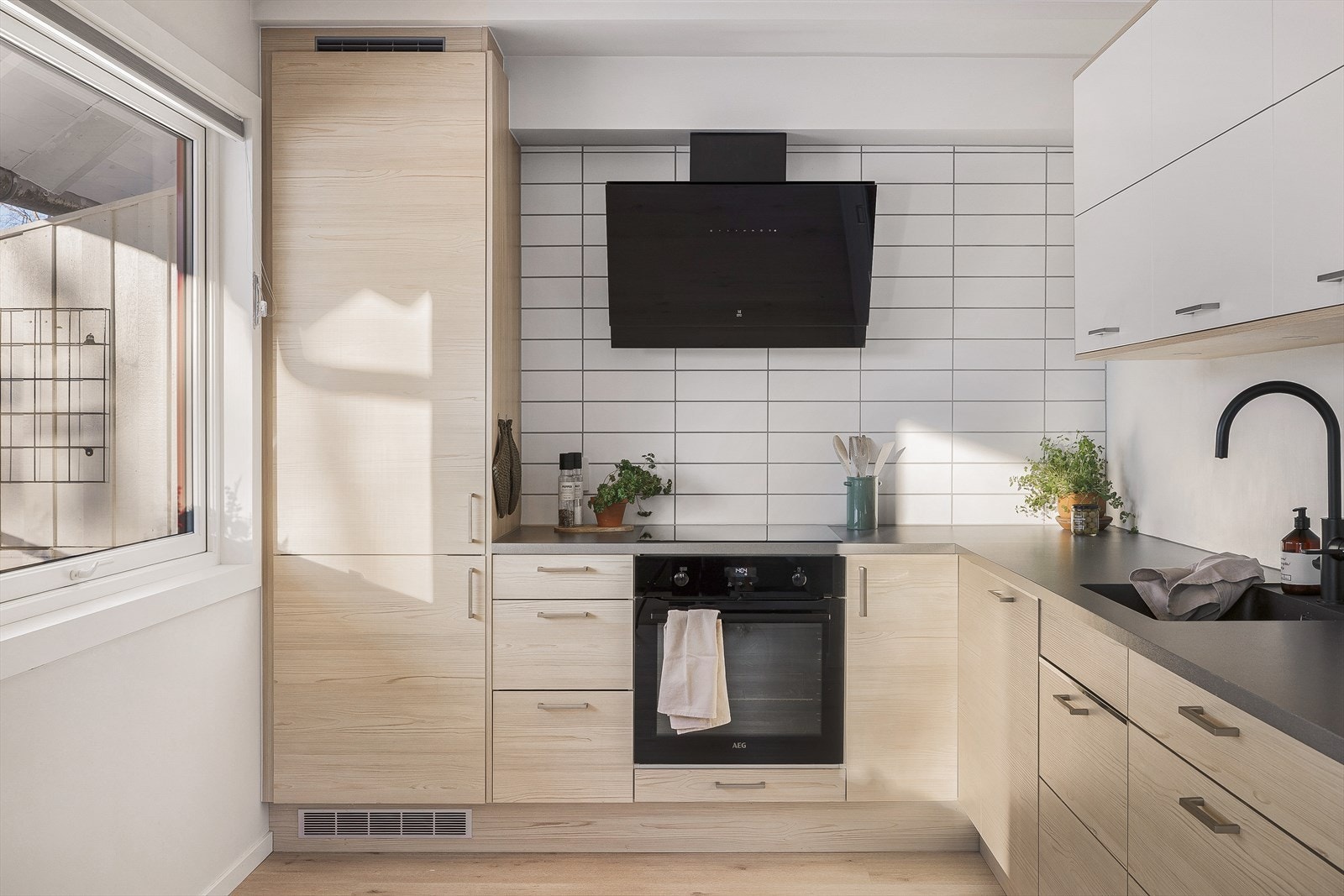 Den lekre ventilatorhetten setter et moderne preg på rommet. Sammen med en stilren underlimt sort servant, moderne sort blandebatteri, og downlights under skap for god benkebelysning har rommet mange fine detaljer man vil sette pris på. Galleribilde