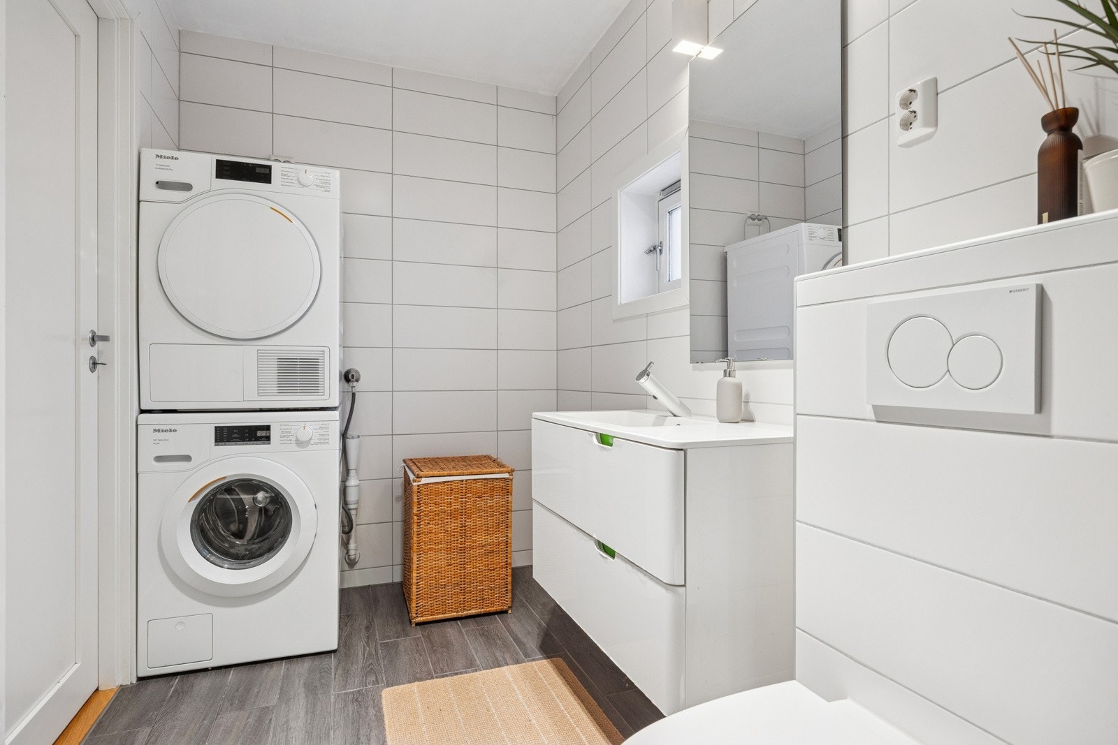 Baderommet er innredet med servant med underskap, dusjhjørne med foldbare glassdører og toalett. Det er også opplegg for både vaskemaskin og tørketrommel. Galleribilde