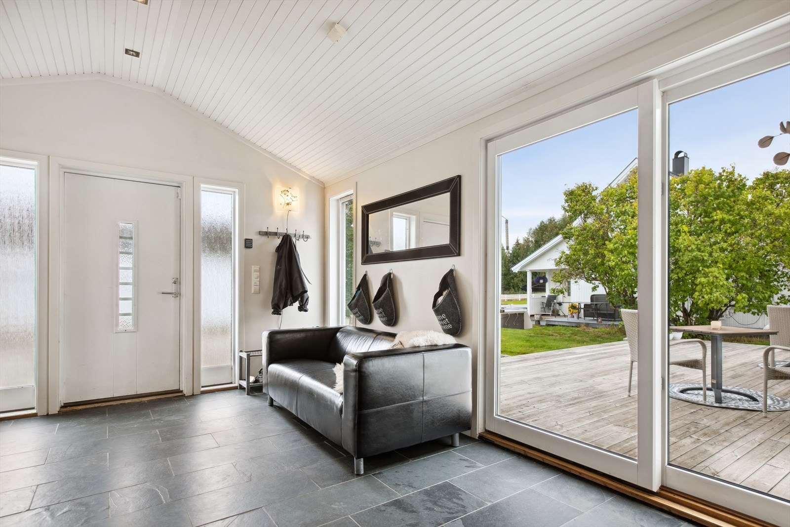 Velkommen inn... Pent flislagt gulv med gulvvarme og god takhøyde. Skyvedører ut mot hage og terrasse. Galleribilde