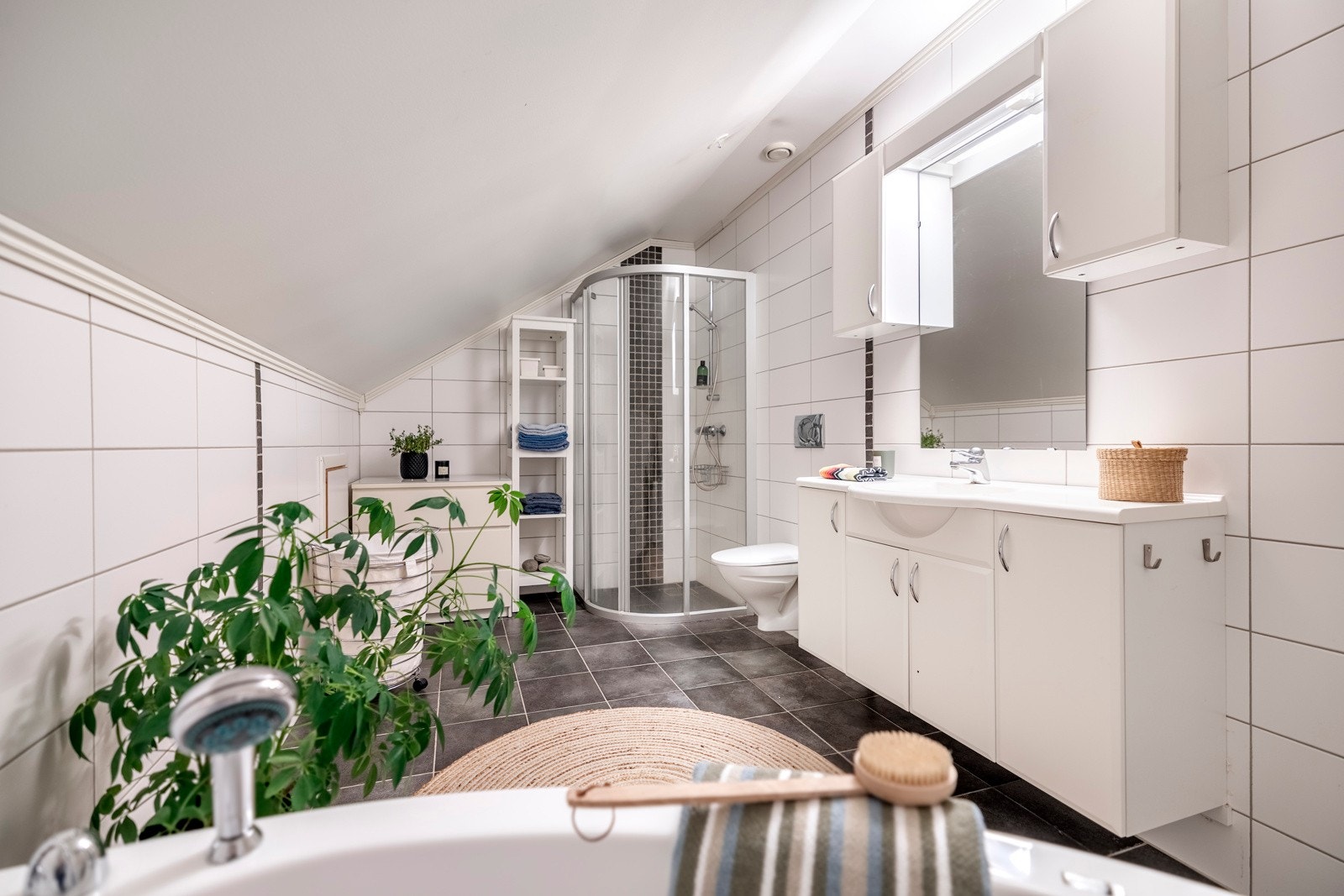 Innredningen består av nedfelt servant, veggmontert toalett, badekar og dusjvegger/hjørne. Galleribilde