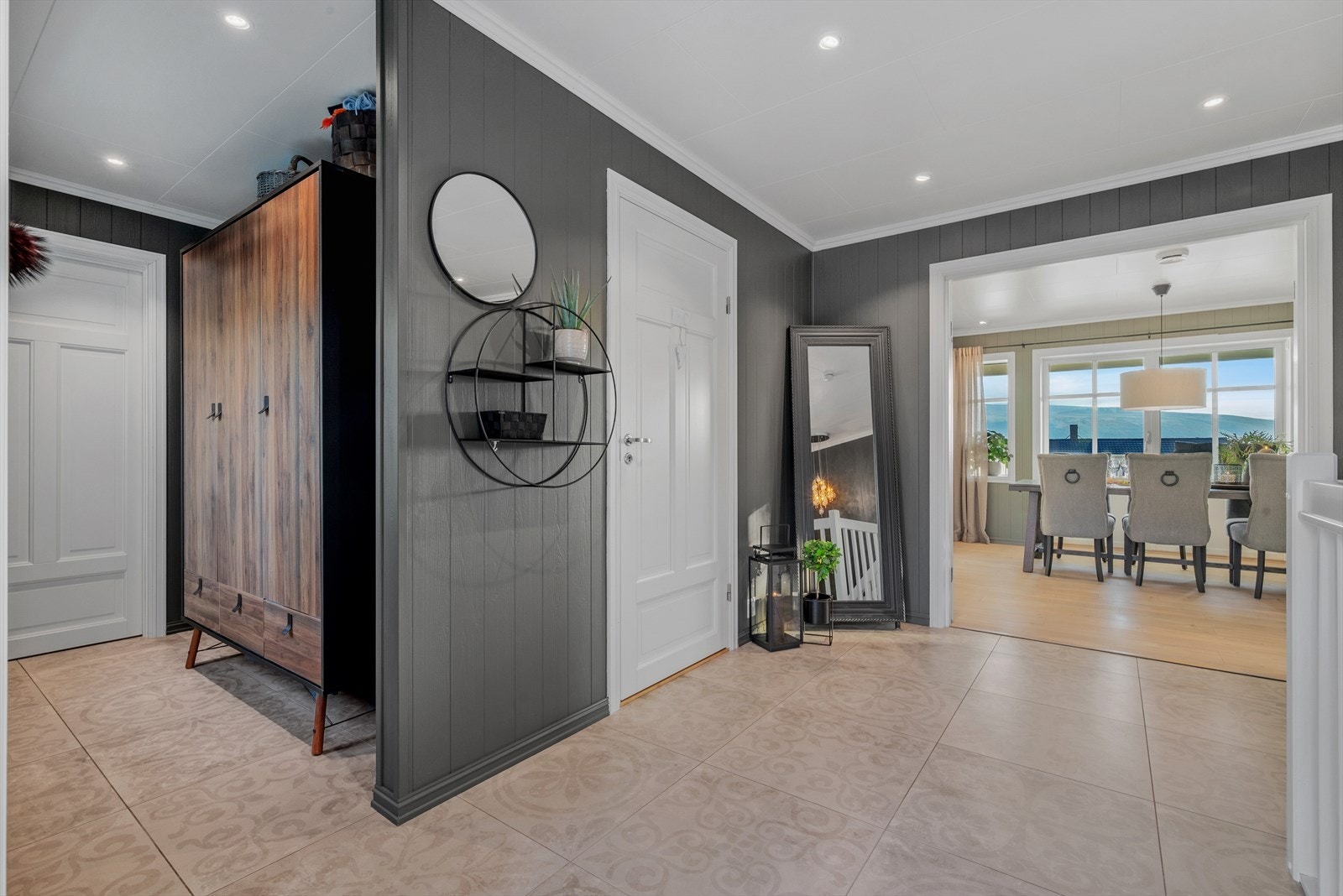 Entreen har flislagt gulv med vakkert mønster, og har selvsagt innlagt varmekabler. Rommet har god plass for garderobeløsning, og har adkomst til innvendig bod og bad. Galleribilde