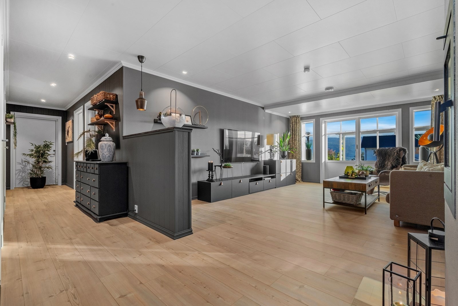 Det er adkomst til kjelleretasjen fra egen ytterdør i enden av gangen, i tillegg til verandadøren i stua. Galleribilde