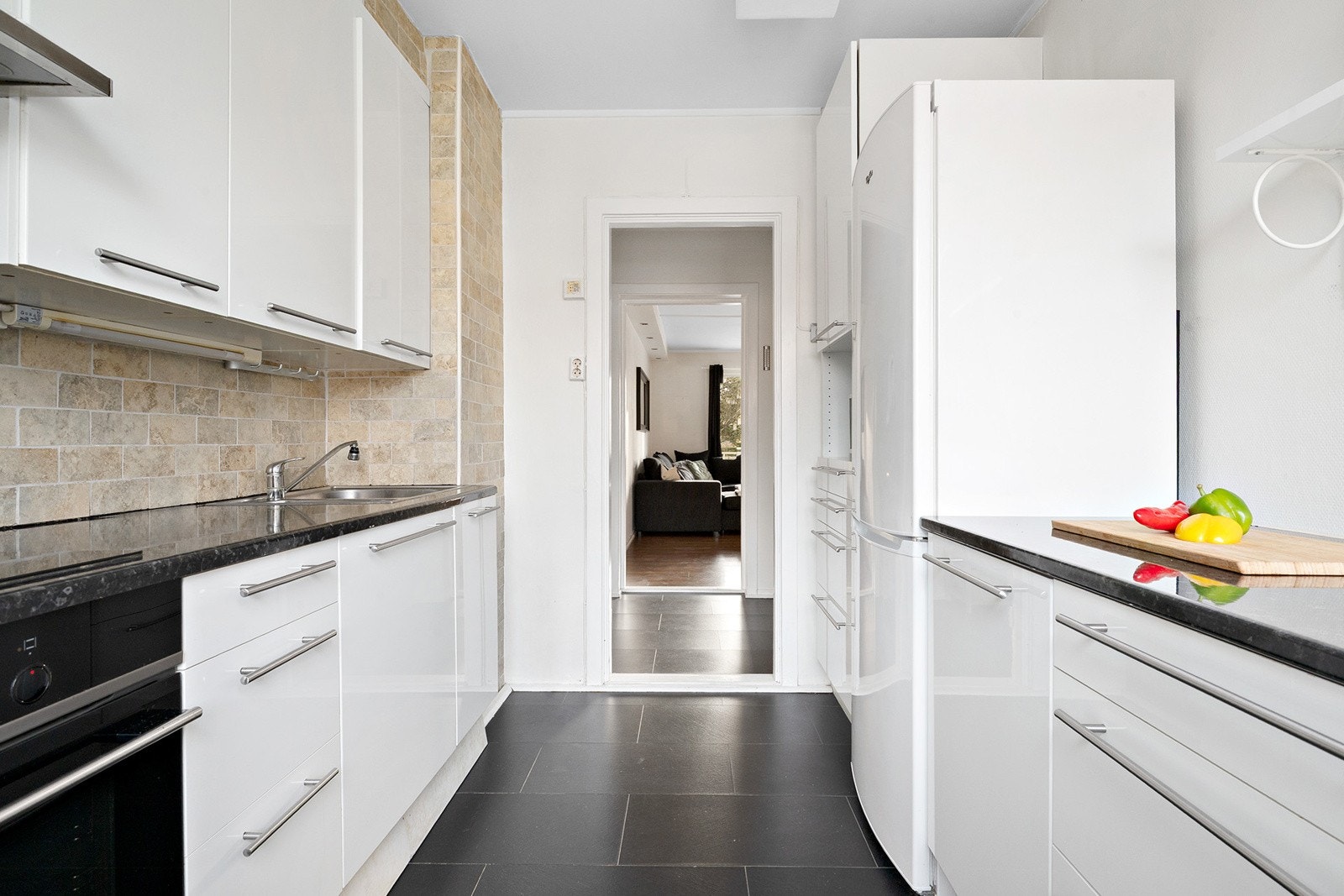 Ikea høyglans kjøkkeninnredning fra 2008 og fra 2014 , laminat benkeplate, ventilator vifte, nedfelt kum, integrert komfyr og platetopp. Galleribilde