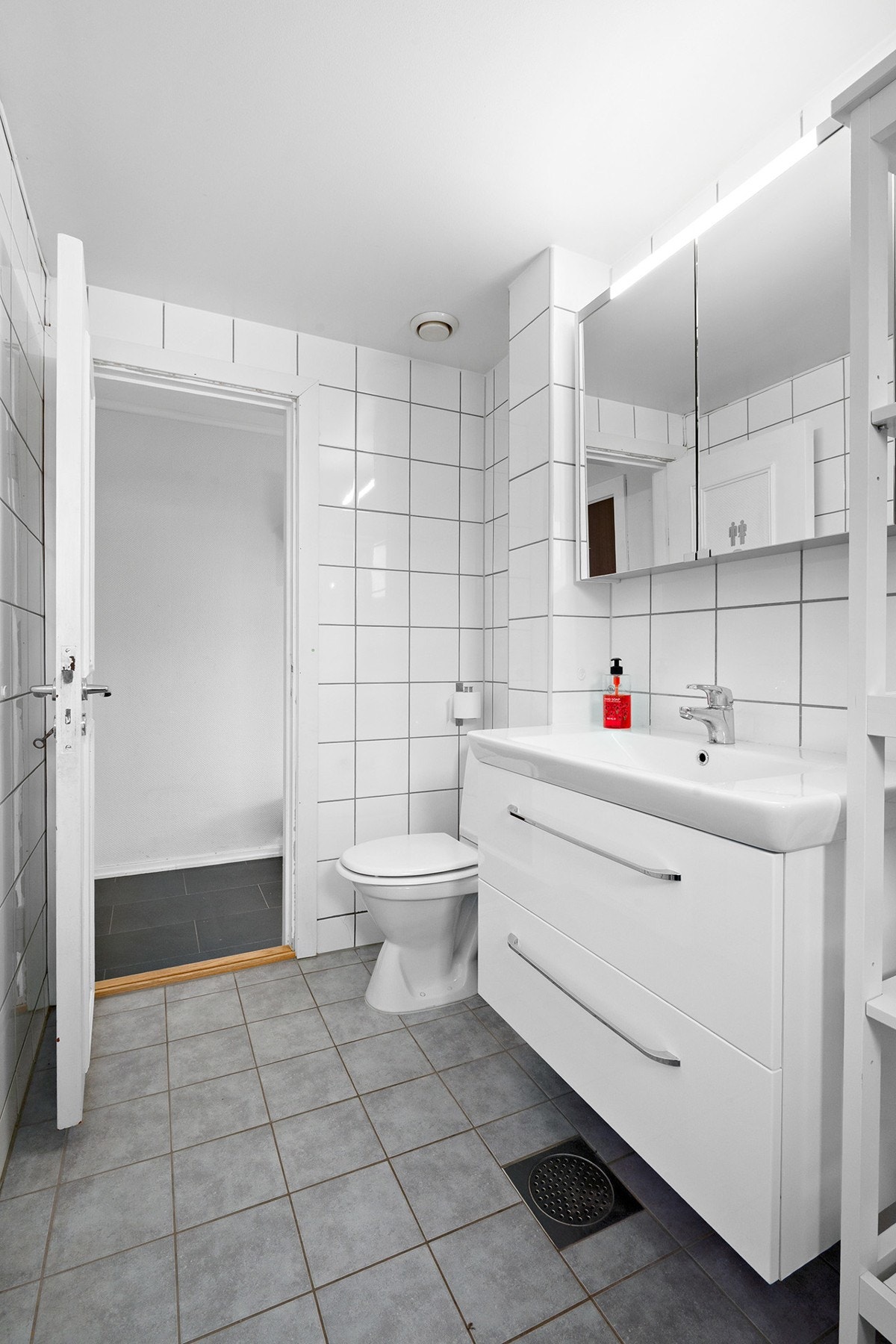 Baderommet består av toalett, servant med skuffer under og dusj i hjørne med innad slående dører. Galleribilde