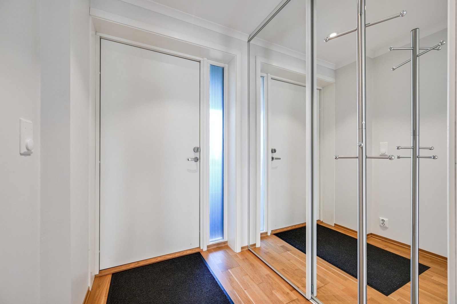 Lys og innbydende entré med godt med garderobeskap. Praktiske speildører. Galleribilde