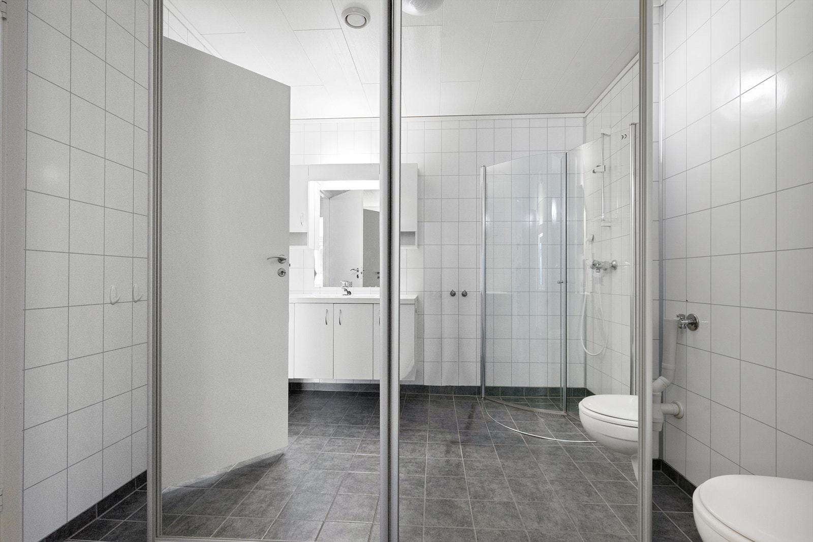 Vaskeromsfunksjoner og skittentøy er skjult bak skyvedørsløsning. Galleribilde