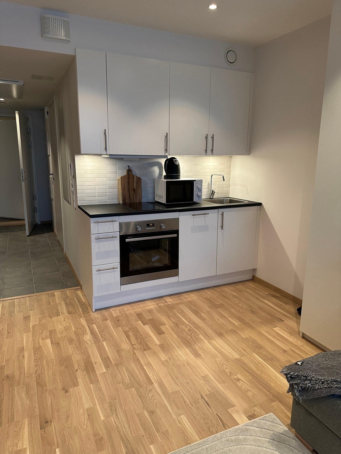 Kjøkken med integrerte hvitevarer som induksjonstopp, stekeovn, oppvaskmaskin og kombi kjøl/frys. Galleribilde