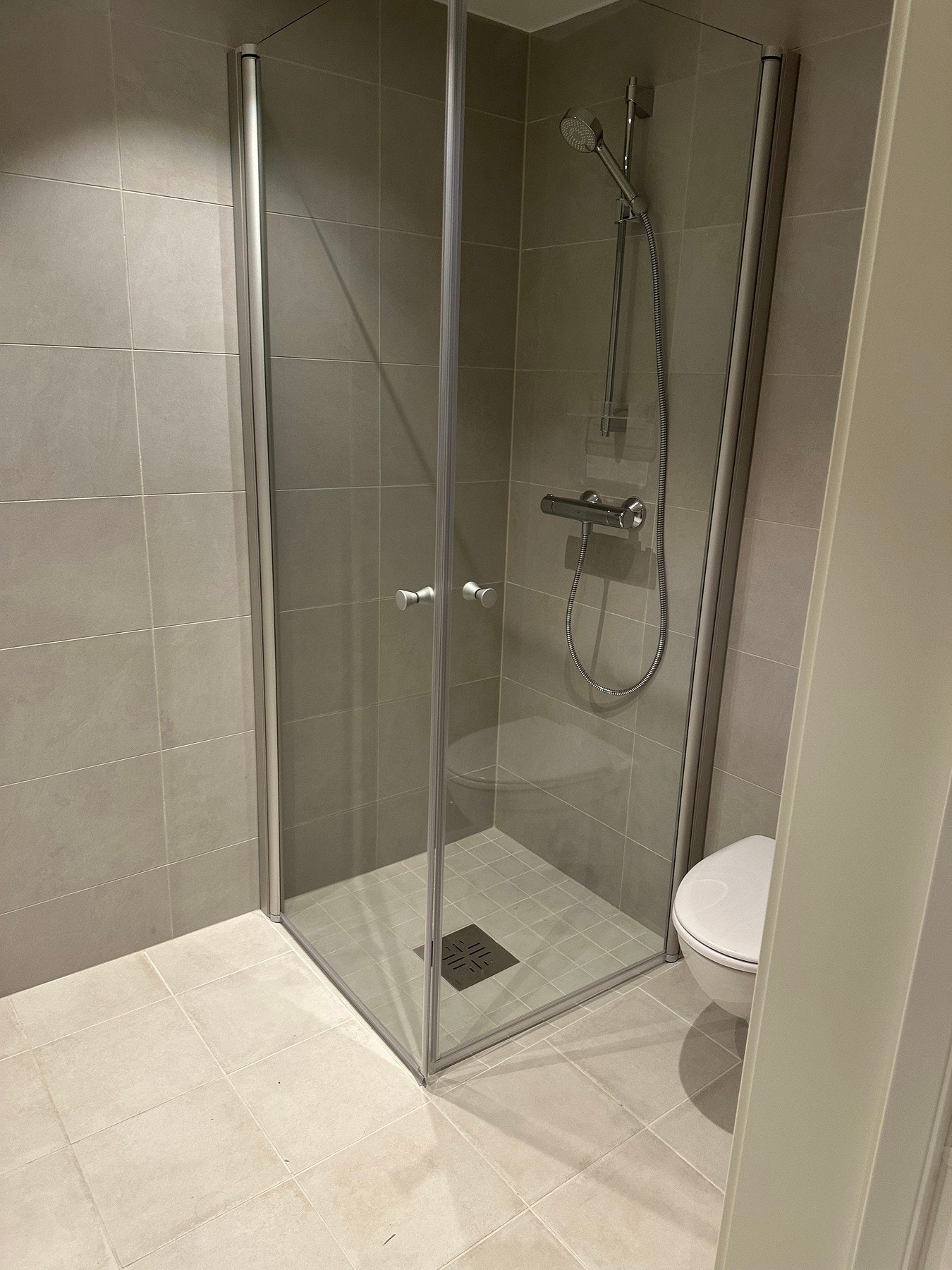 Baderom med gulvvarme, dusjnisje med glassvegger og vegghengt WC. Opplegg for vaskemaskin. Galleribilde