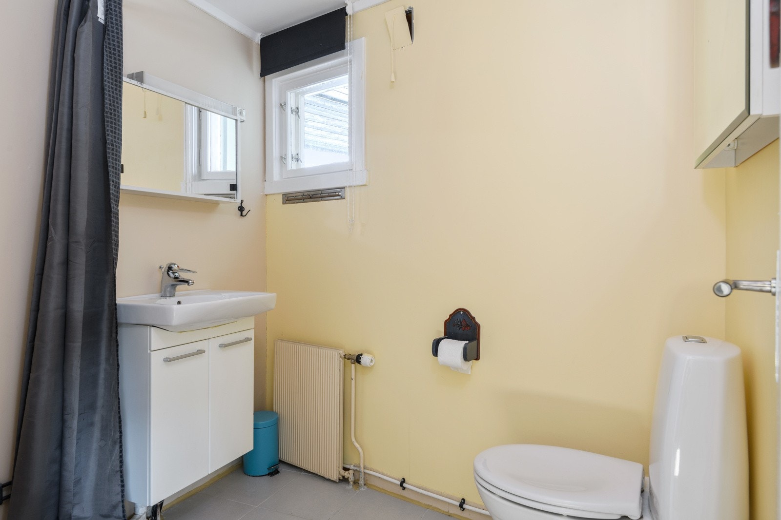 Baderommet i hybelen ble oppgradert i ca. 2018. Baderommet har fliser på gulv, overflater med vinyltapet og malte plater og et lite vindu som slipper inn dagslys. Galleribilde