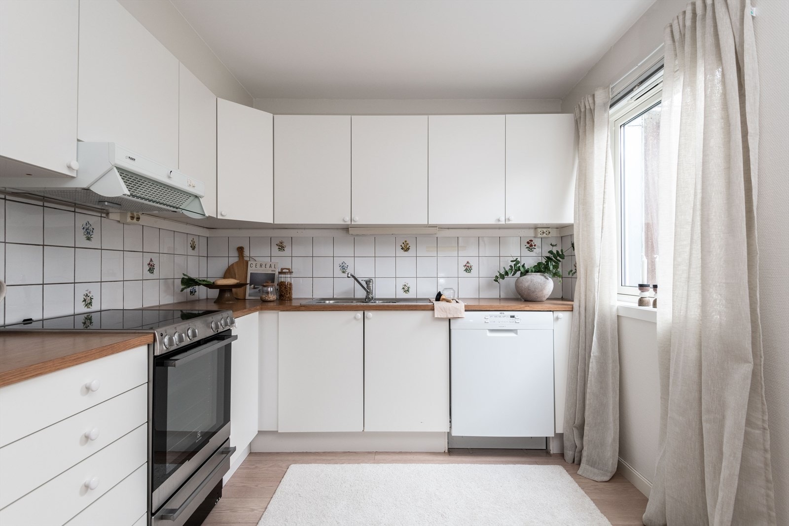 Kjøkkeninnredning med hvite slette fronter og laminert benkeplate Galleribilde