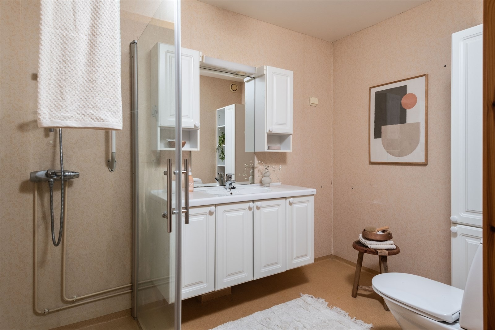 Badet er innredet med dusjhjørne, servantskap, speil, gulvstående wc og opplegg for vaskemaskin. Galleribilde