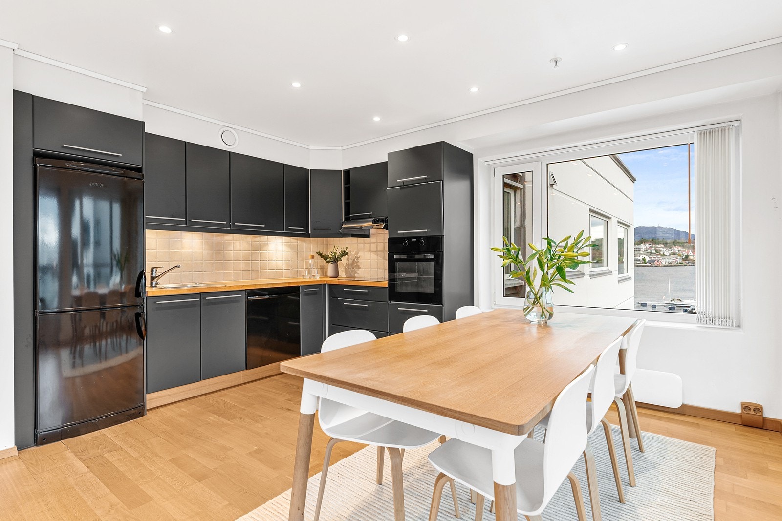 Kjøkkeninnredningen er svart foliefront med heltre benkeplate og nedfelt stålvask Galleribilde