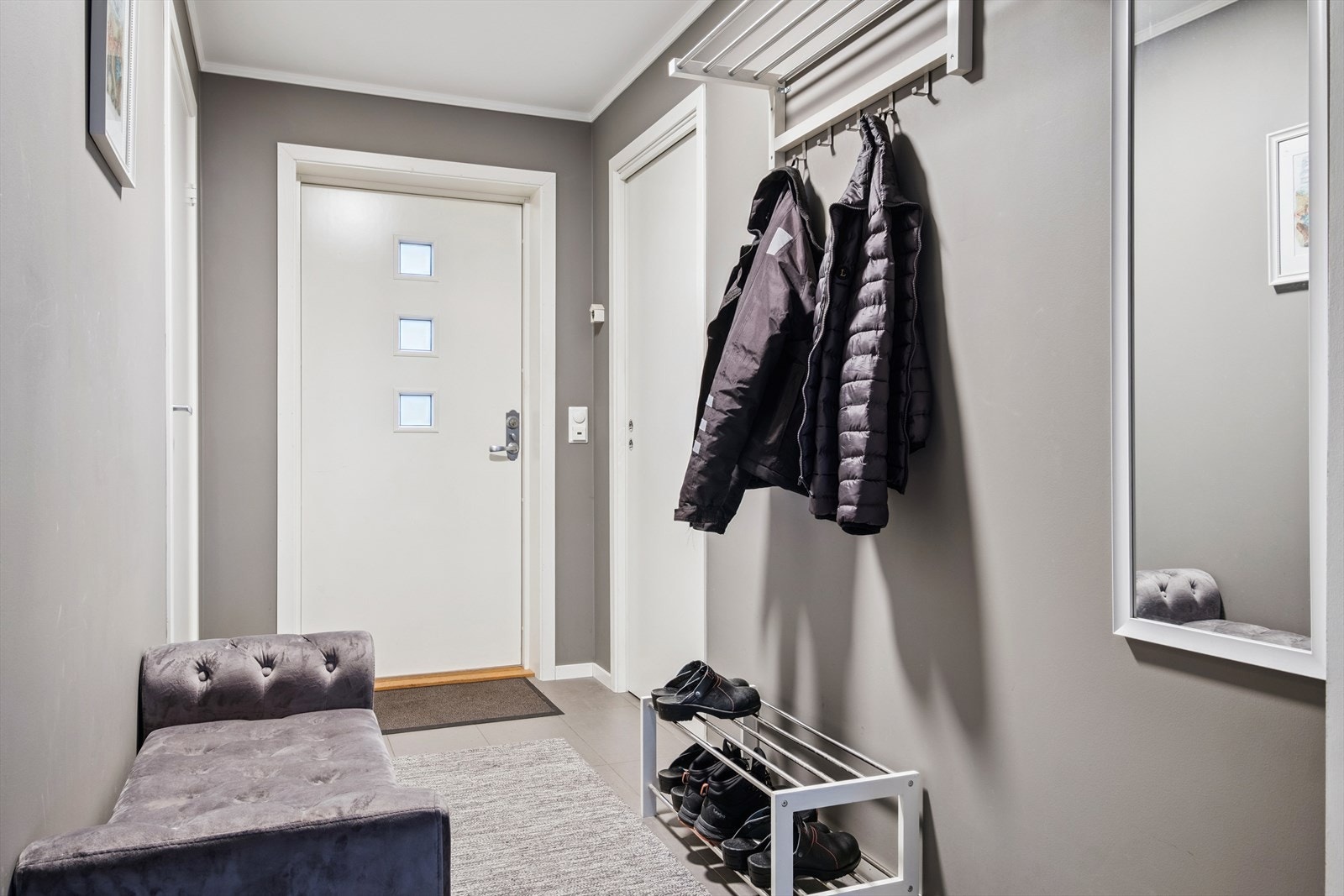 Pent flislagt inngangsparti med oppheng av klær og sko. Varme i gulv. Galleribilde