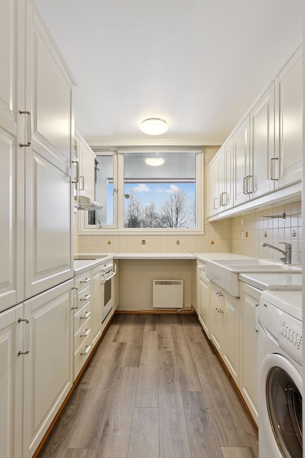 Kjøkkenet har integrerte hvitevarer som platetopp, stekeovn, oppvaskmaskin og kjøle/fryseskap. Galleribilde