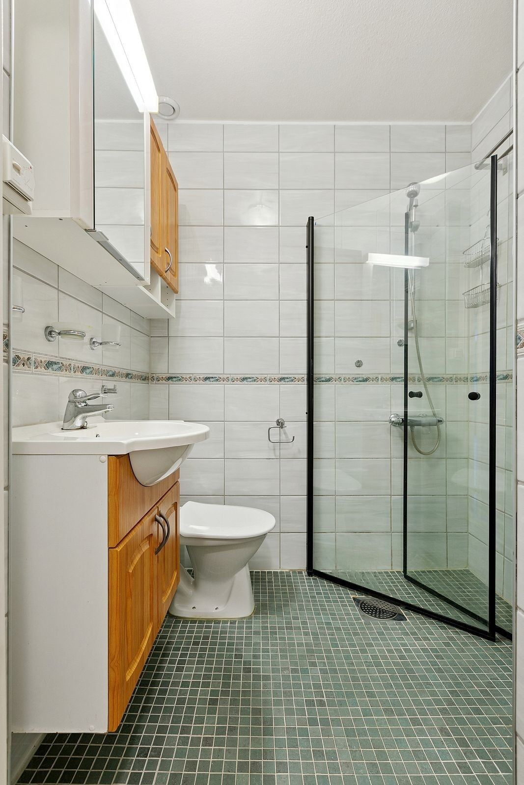 Baderomsinnredning har servant med underskap, speilskap med lys, høyskap og 2 veggskap Galleribilde